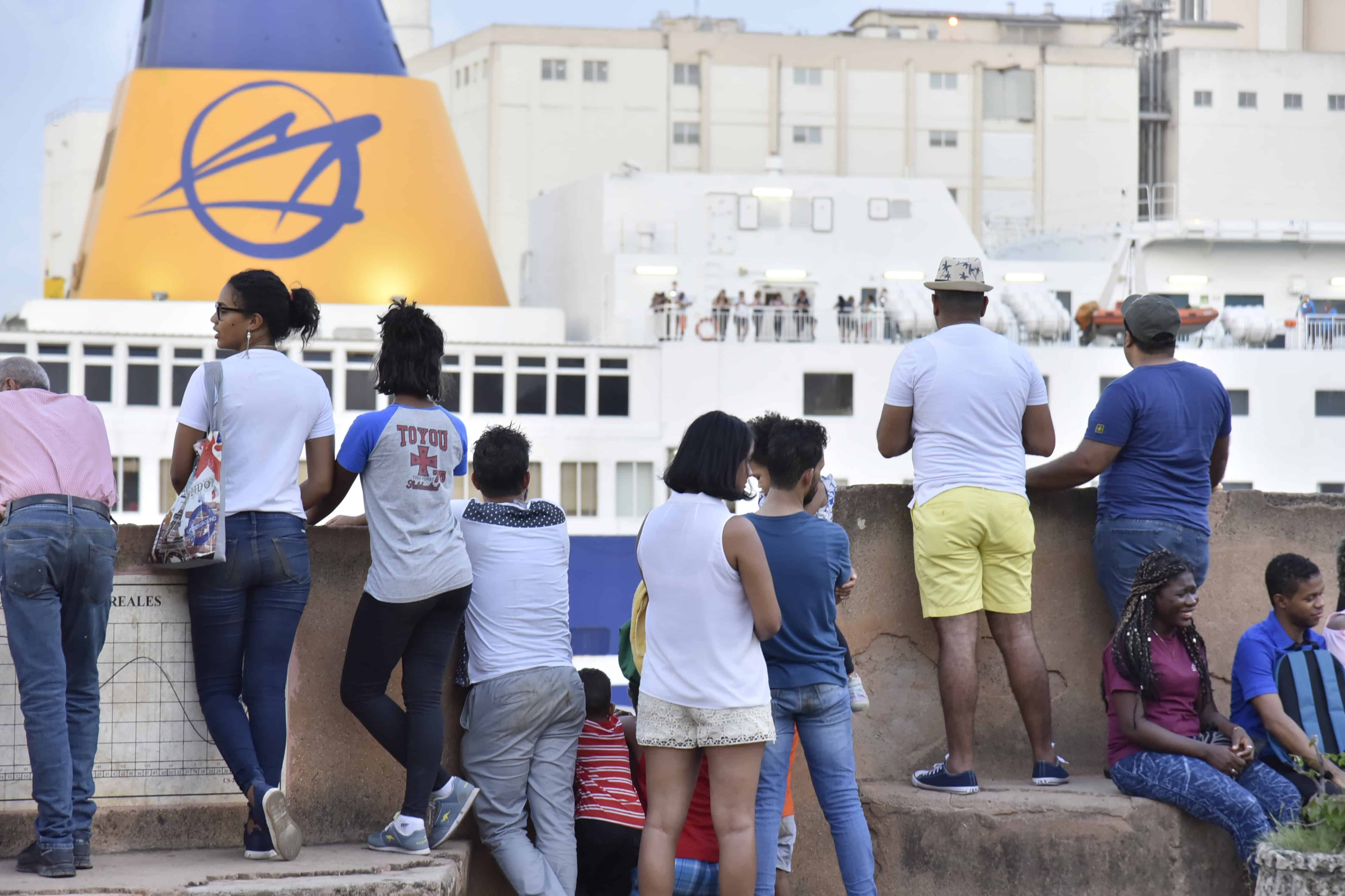Un grupo de personas observa la llegada del ferry en el r&iacute;o Ozama.