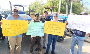 Tres a&ntilde;os sin cobrar: due&ntilde;os de tractores bloquean carretera en Montecristi