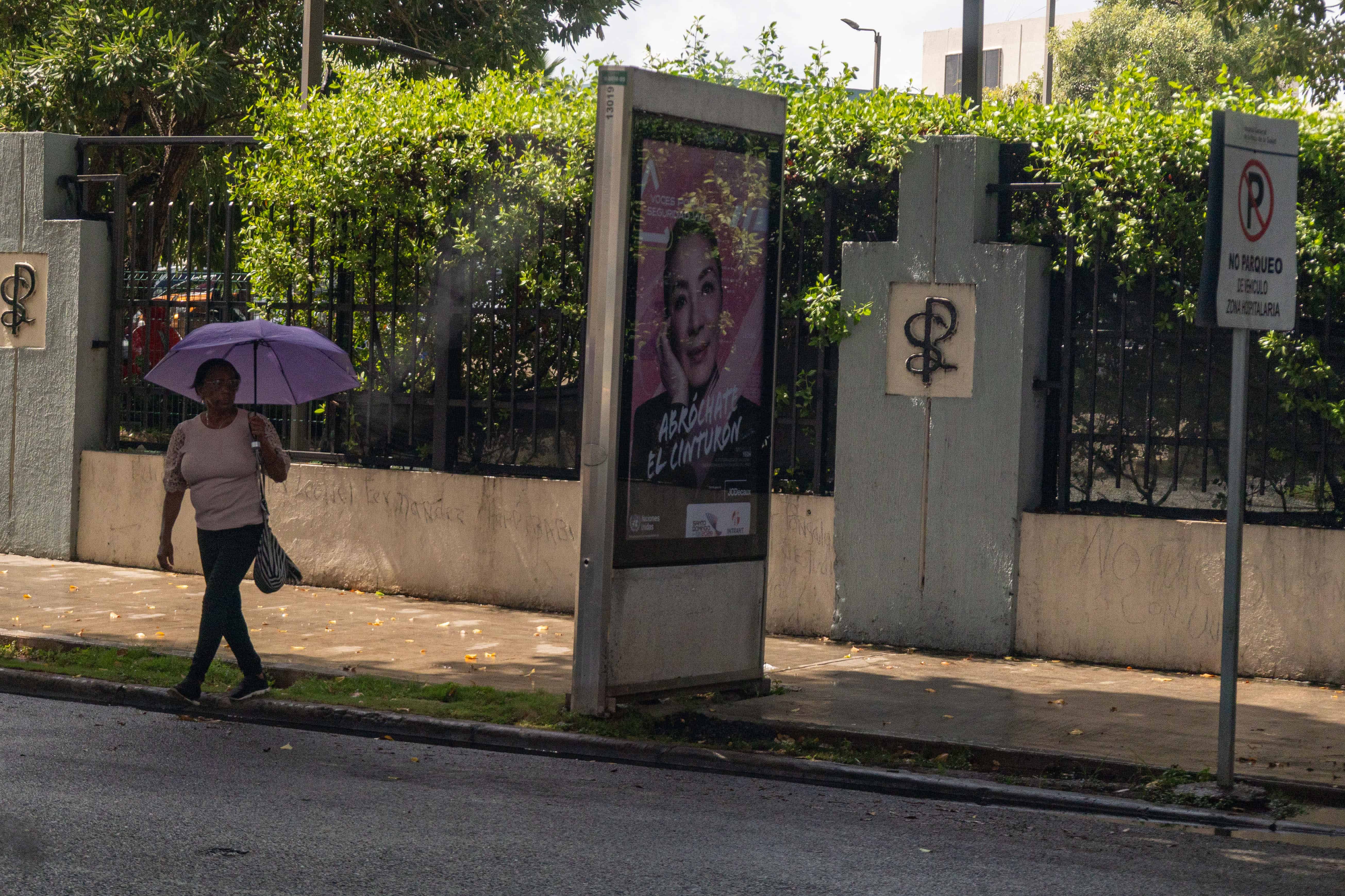 Peatones se desplazan con sombrillas tras las lluvias registradas.
