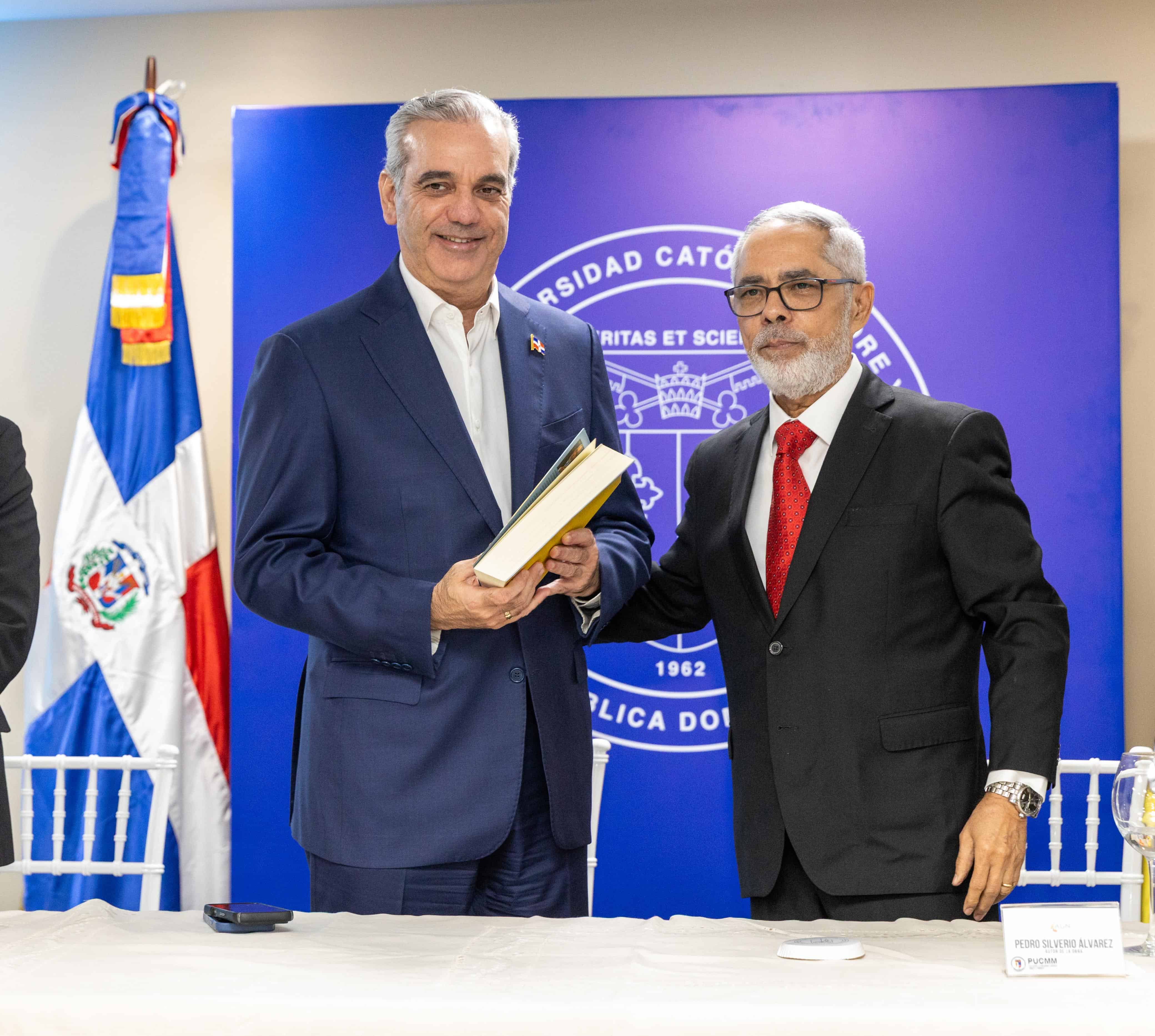 El presidente de la República, Luis Abinader recibe de mano del economista Pedro Silverio Álvarez, su libro "Ensayos de Economía Pública Dominicana: La interacción entre economía, política e institución".<br>