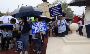 Bioanalistas desaf&iacute;an fuerte lluvia para exigir mejores salarios y pensiones dignas