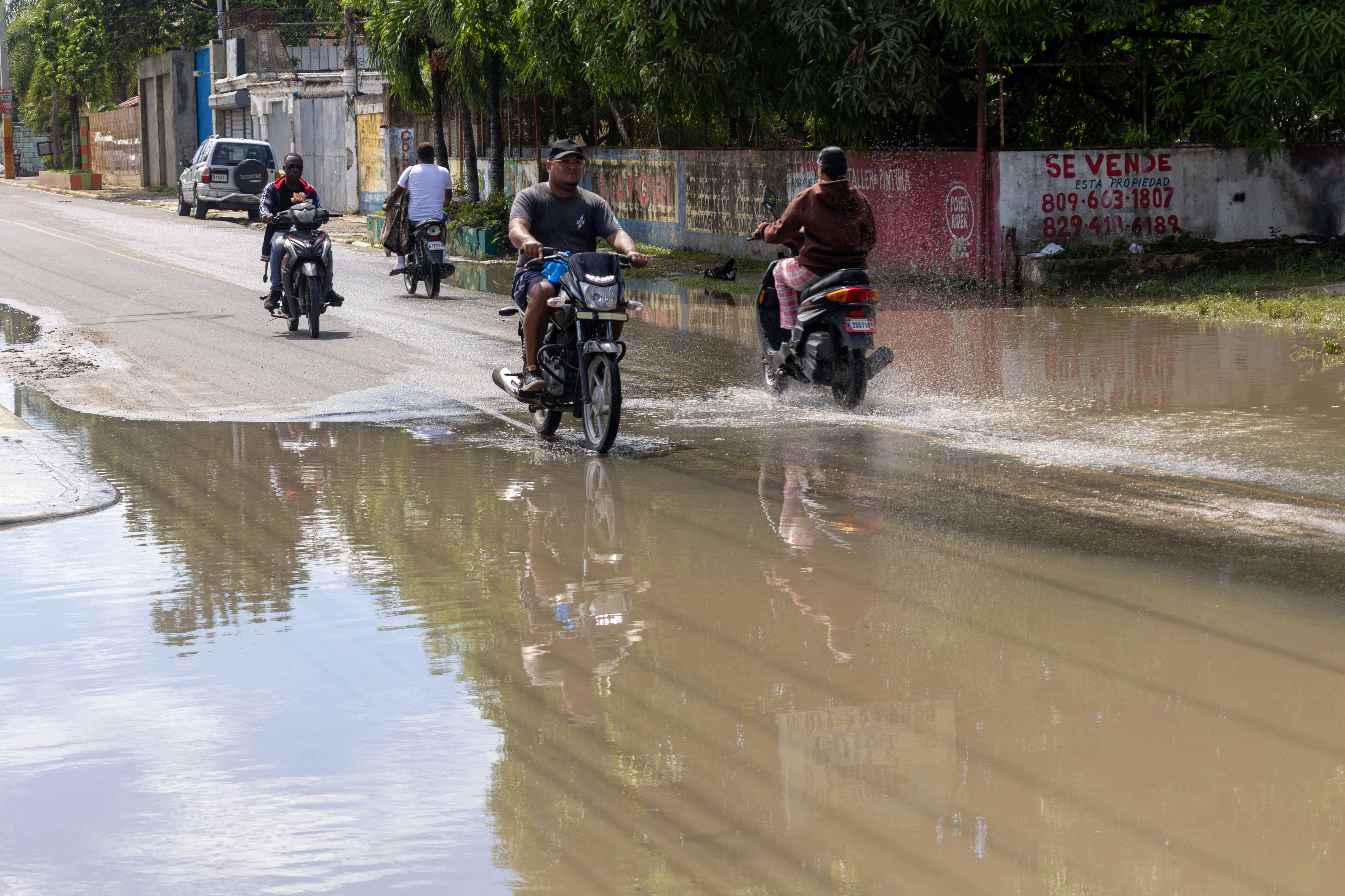 Motoristas levantaban los pies para evitar el contacto con el agua acumulada al atravesar la calle Francisco Pe&ntilde;a G&oacute;mez, en San Luis.