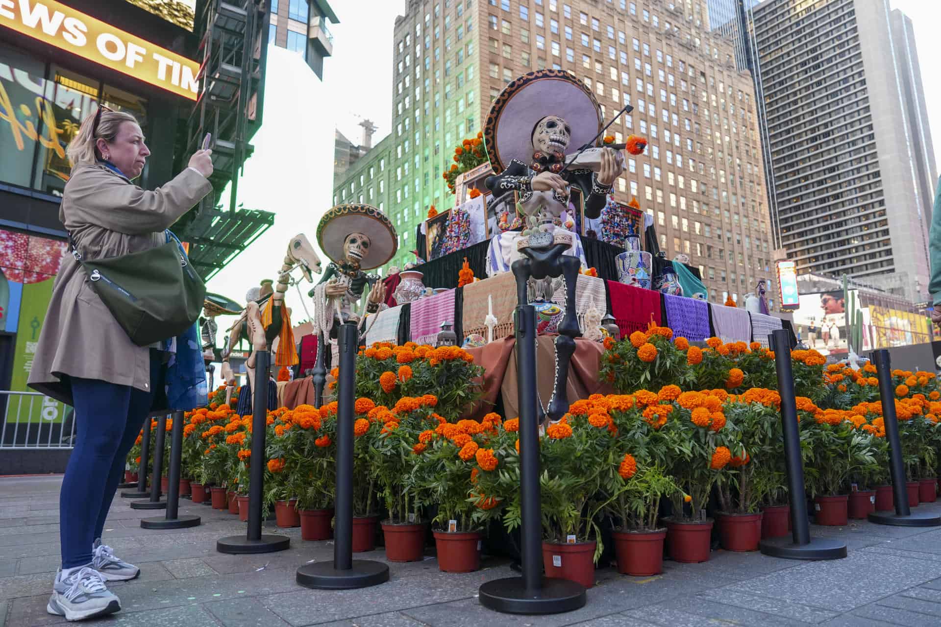 Una mujer toma una fotograf&iacute;a a un altar por el D&iacute;a de los Muertos este viernes, en Times Square de Nueva York (EE.UU.). 
