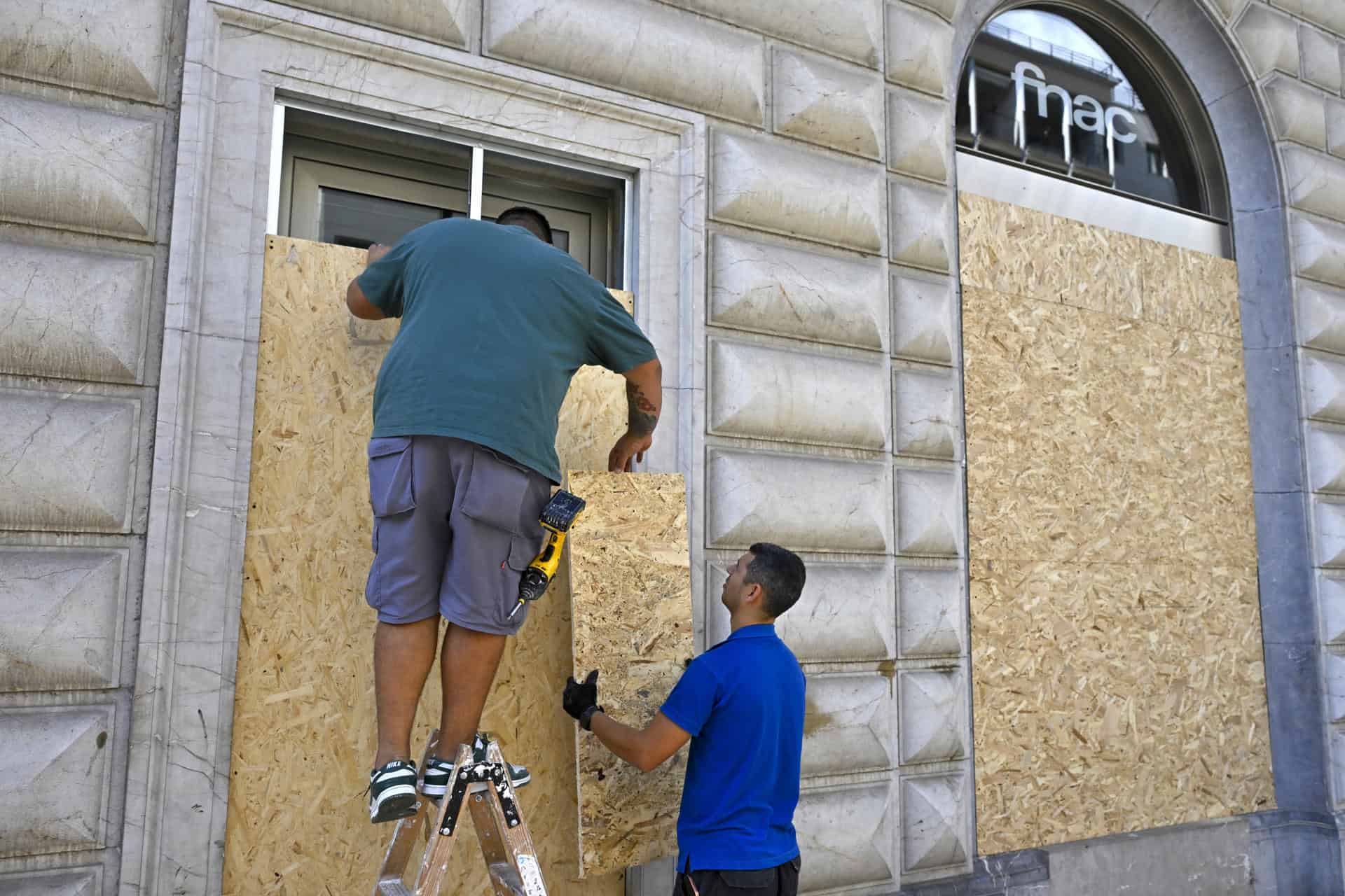 Comercios del centro de Palma (Mallorca) protegen sus escaparates ante la manifestación convocada por la organización Blocus.
