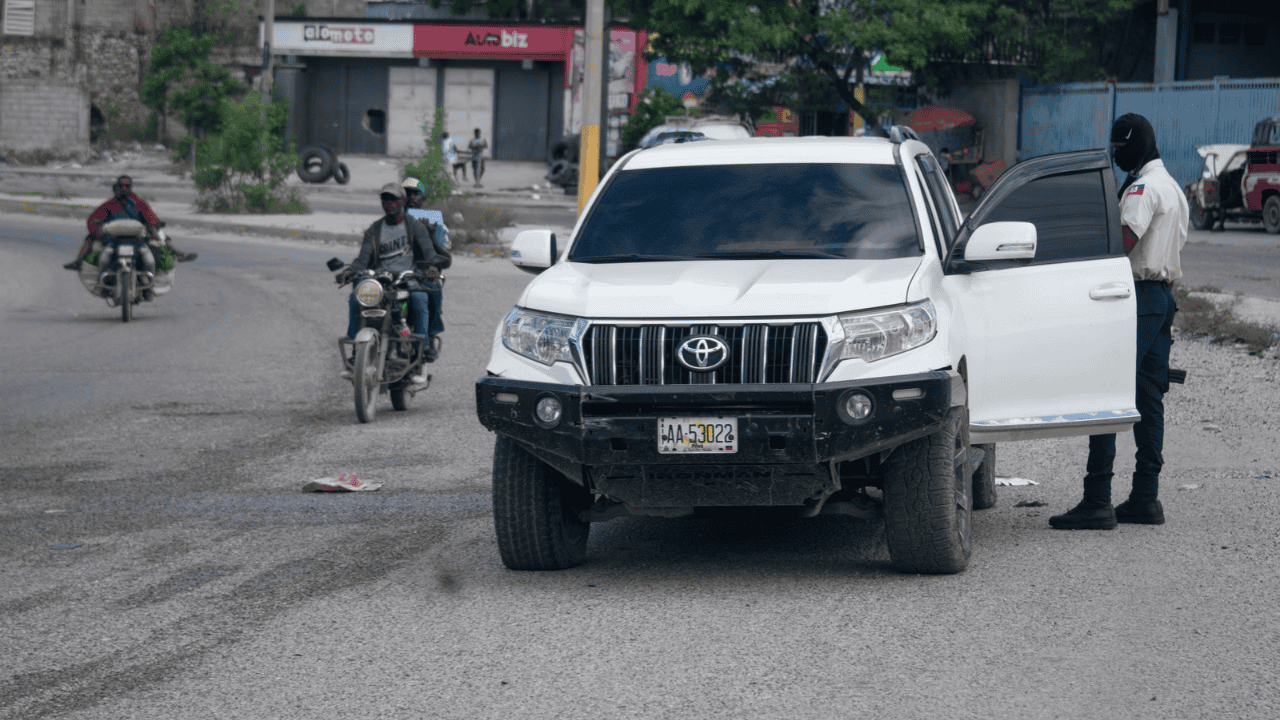 Un policía haitiano revisa los documentos de un conductor el pasado sábado, mientras continuaba la búsqueda de cuatro militares salvadoreños.