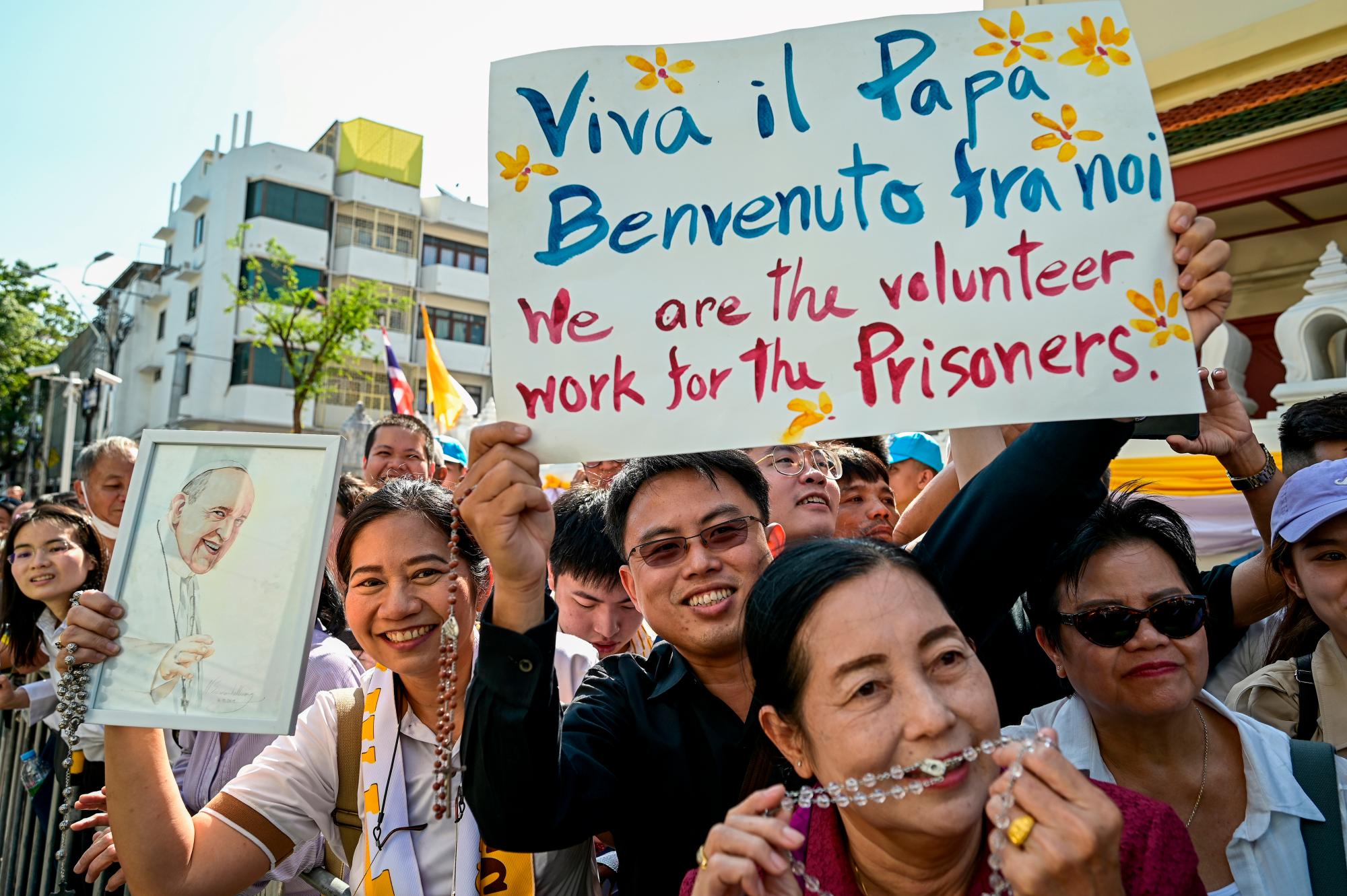 Un hombre sostiene un cartel para dar la bienvenida al Papa Francisco mientras esperan su llegada a Bangkok el 21 de noviembre de 2019. 