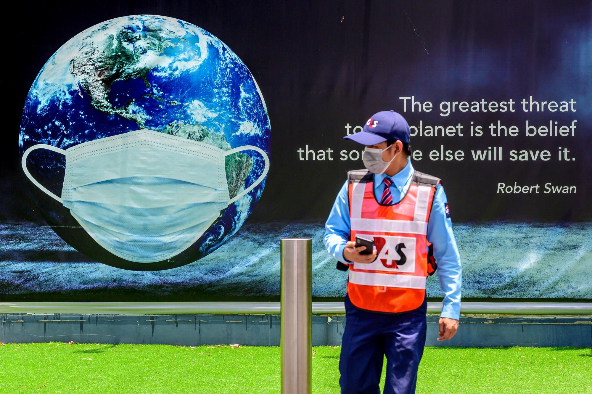 Un guardia de seguridad aguarda frente a un poste en el que reza la frase de Robert Swan El peligro más grande para el planeta, es creer que alguien más lo salvará (Foto: Mladen ANTONOV / AFP)