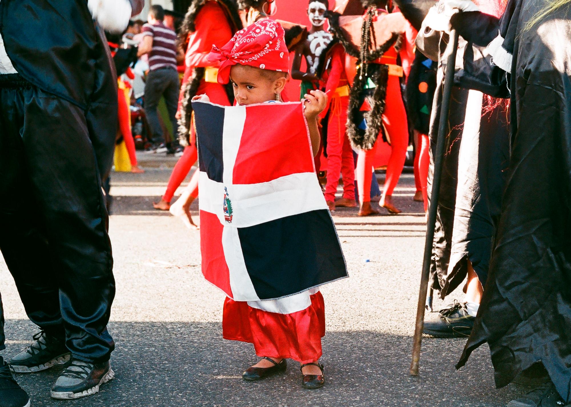 Niña vestida de la bandera dominicana en el carnaval.