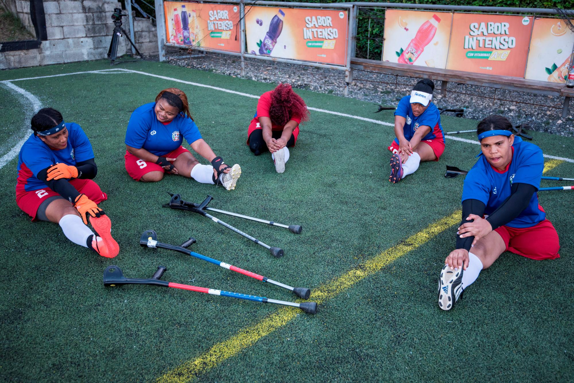 Jugadoras de fútbol de la selección femenina de República Dominicana hacen estiramientos antes de empezar el partido en contra de la selección femenina de Haití en el marco del evento “Dos muletas y un balón” con motivo del décimo aniversario del terremoto de Haití, hoy sábado en Santo Domingo (República Dominicana).