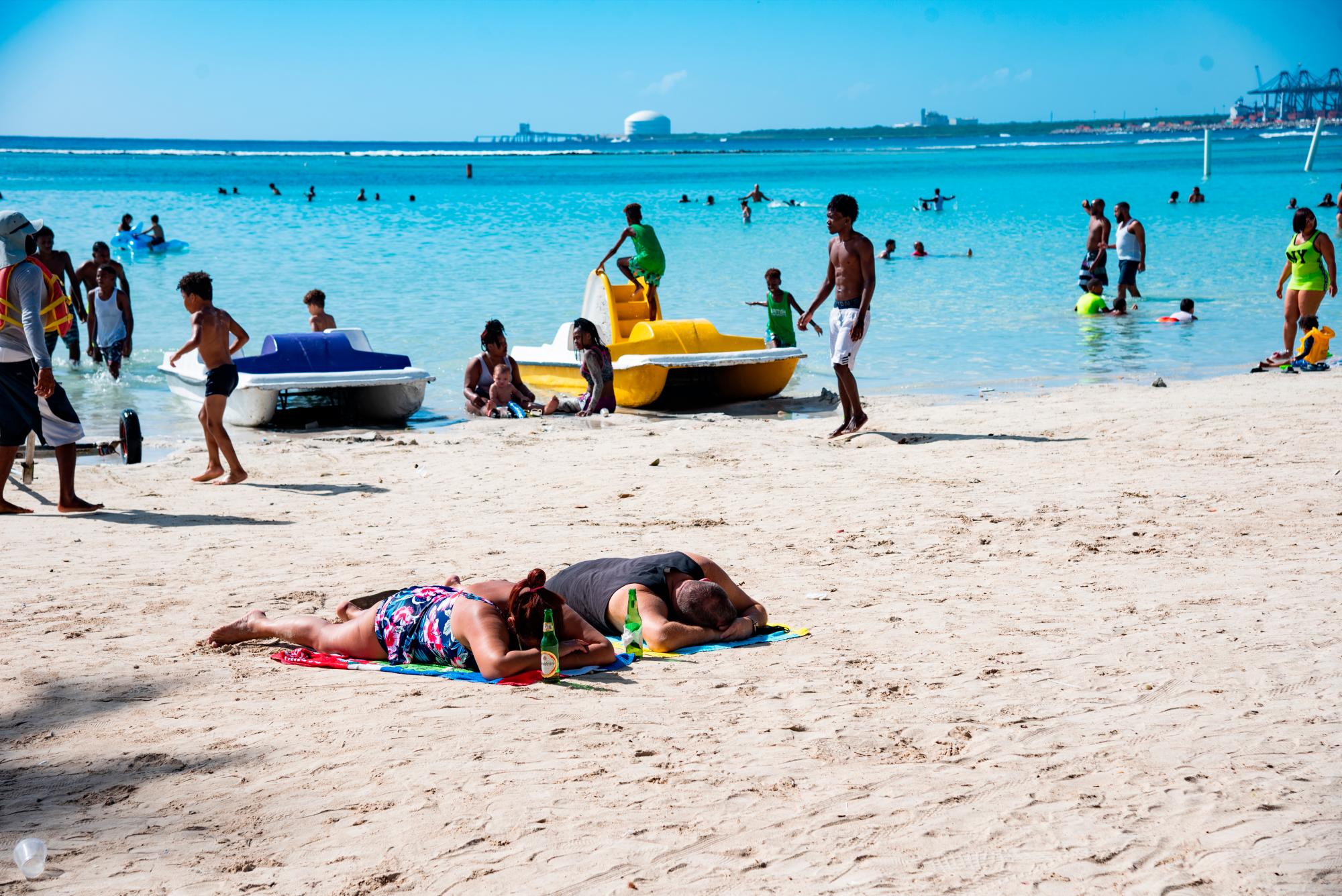 Personas disfrutando del sol, con dos botellas de bebida alcohólica, En la Playa Boca Chica el pasado viernes 01 del 2021.