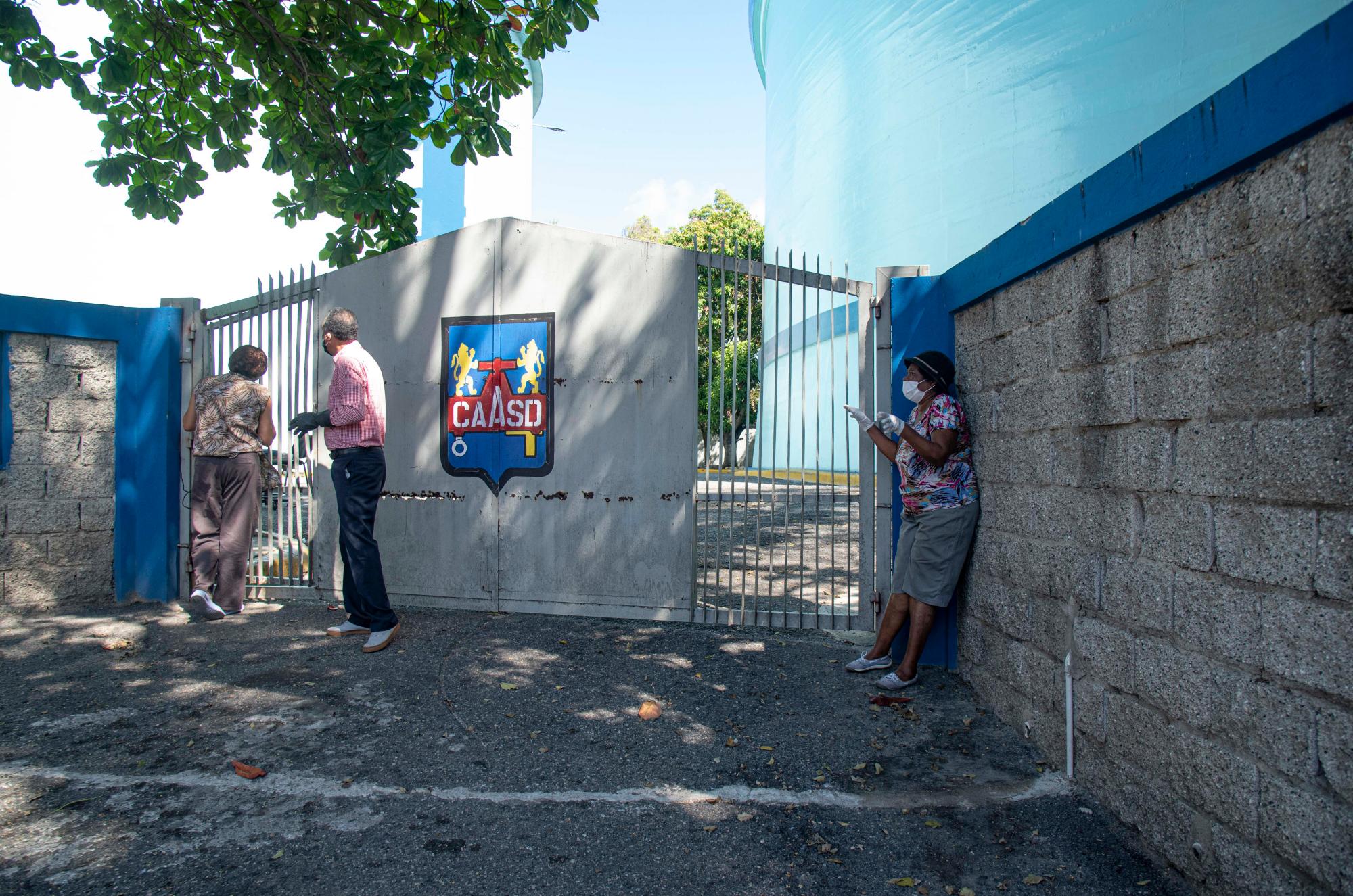 Vecinos tienen que buscar latas de agua en esos enorme tanque frente a sus casas.