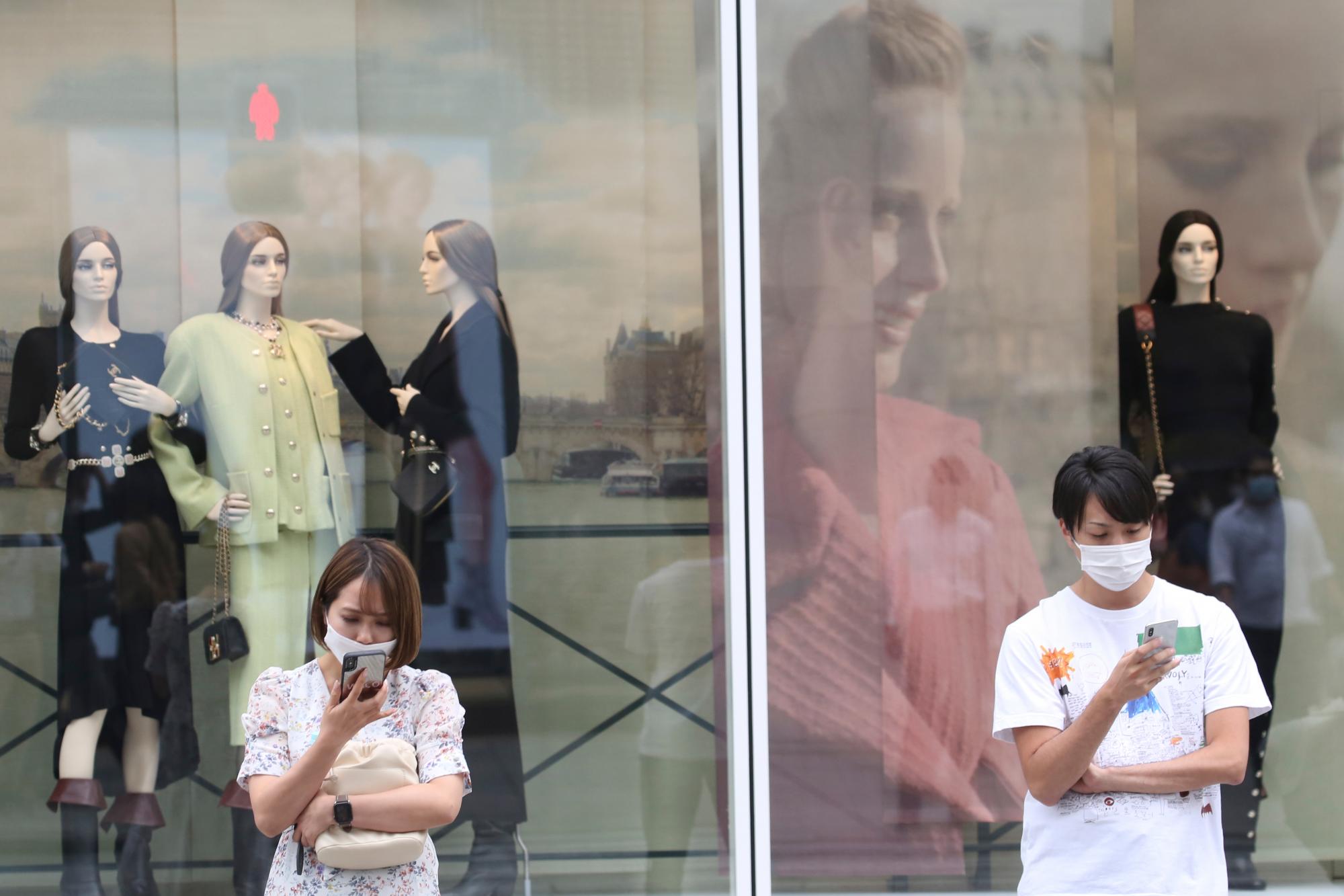 Personas con máscaras faciales para protegerse contra la propagación del nuevo coronavirus están en el distrito comercial de Ginza en Tokio, el miércoles 7 de octubre de 2020 