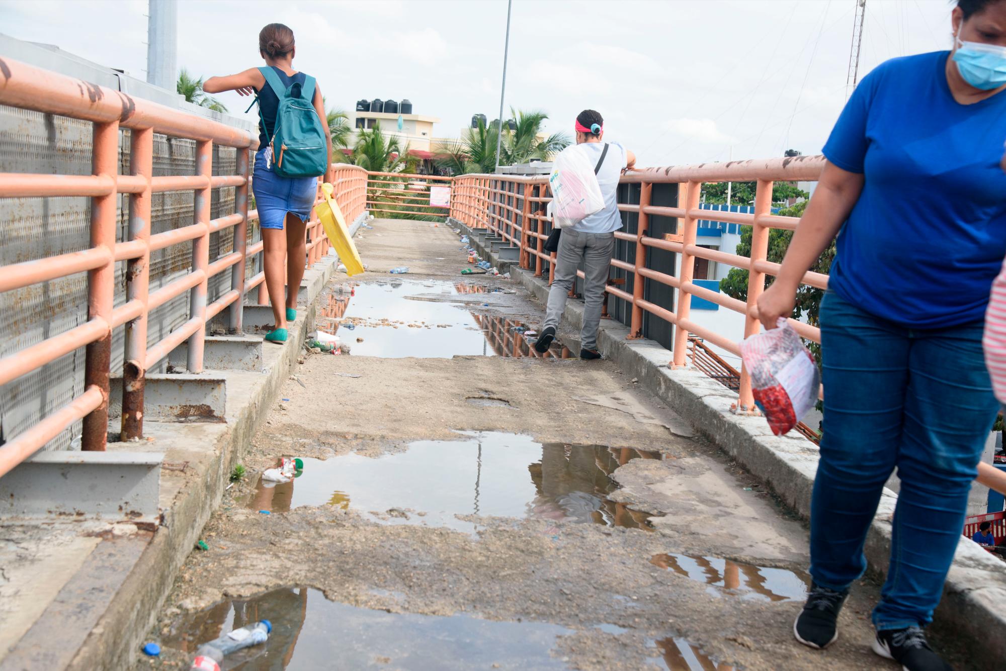 La gente camina pagada a la verja para no mojarse los pies