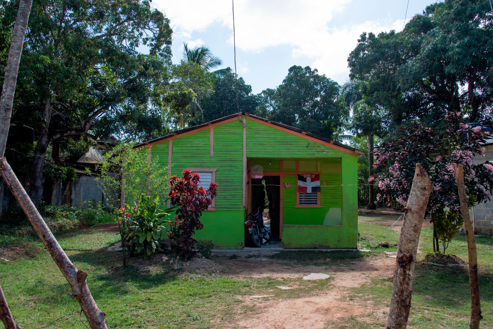 Casa de madera con una bandera de la República Dominicana en la comunidad La Ceiba, en La Victoria, del municipio Santo Domingo Norte.