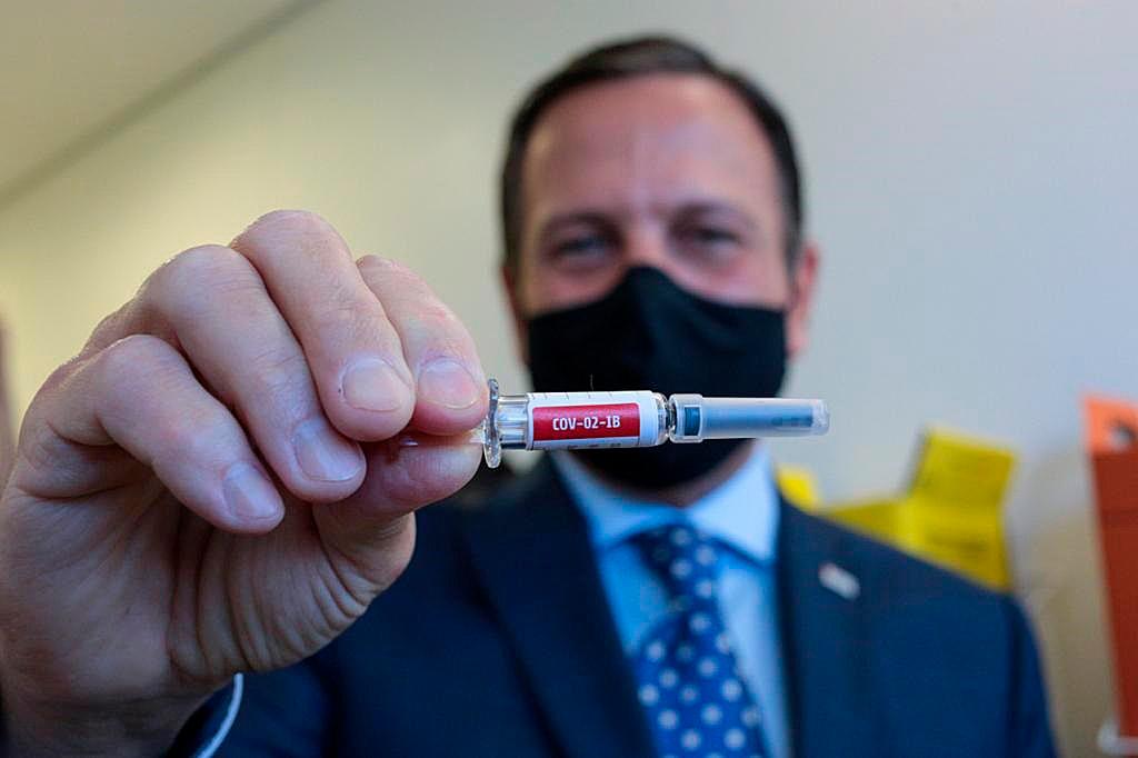 Fotografía cedida por el Gobierno de Sao Paulo que muestra al gobernador João Dória mientras sostiene una de las vacunas contra el nuevo coronavirus