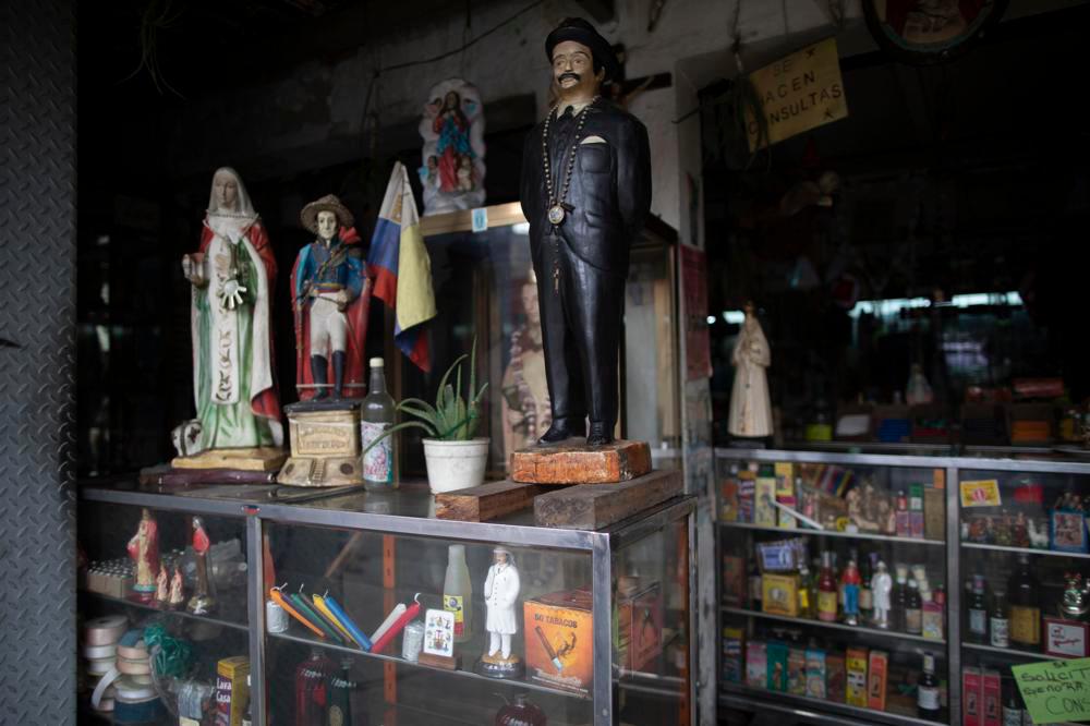 Una imagen del doctor venezolano José Gregorio Hernández , sobre un expositor junto a otras estatuas de santos, en una tienda esotérica en Caracas, Venezuela, el 28 de abril de 2021. Conocido como el 'médico de los pobres', Hernández será beatificado el 30 de abril por la Iglesia católica, un paso hacia su santidad. 