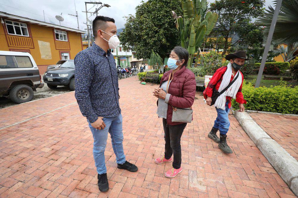 Con máscaras para frenar la propagación del nuevo coronavirus, el alcalde Jaime Rodríguez, a la izquierda, conversa con un residente en Campohermoso, Colombia, el jueves 18 de marzo de 2021. Rodríguez ha sido el único residente del pueblo que contrajo COVID-19 cuando viajó a Bogotá pero se quedó allí hasta que recuperarse para evitar contagiar la enfermedad en su ciudad natal.  