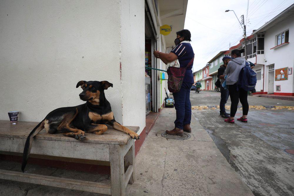 Los residentes compran víveres en la puerta del supermercado luego de que fuera cerrado debido a la nueva pandemia de coronavirus en Campohermoso, Colombia, el jueves 18 de marzo de 2021.