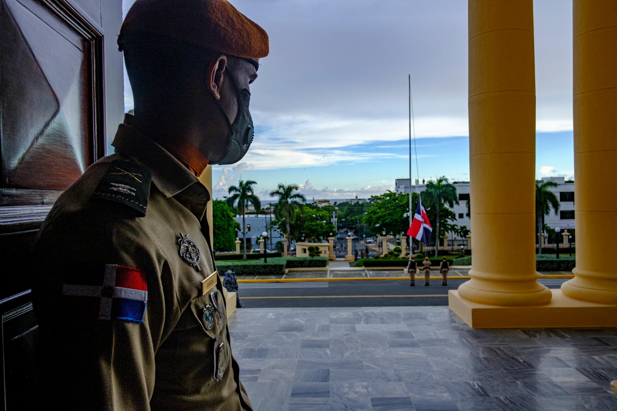 Un guardia presidencial observa la ceremonia de arriado de la Bandera Nacional desde el lobby del Palacio Nacional.  