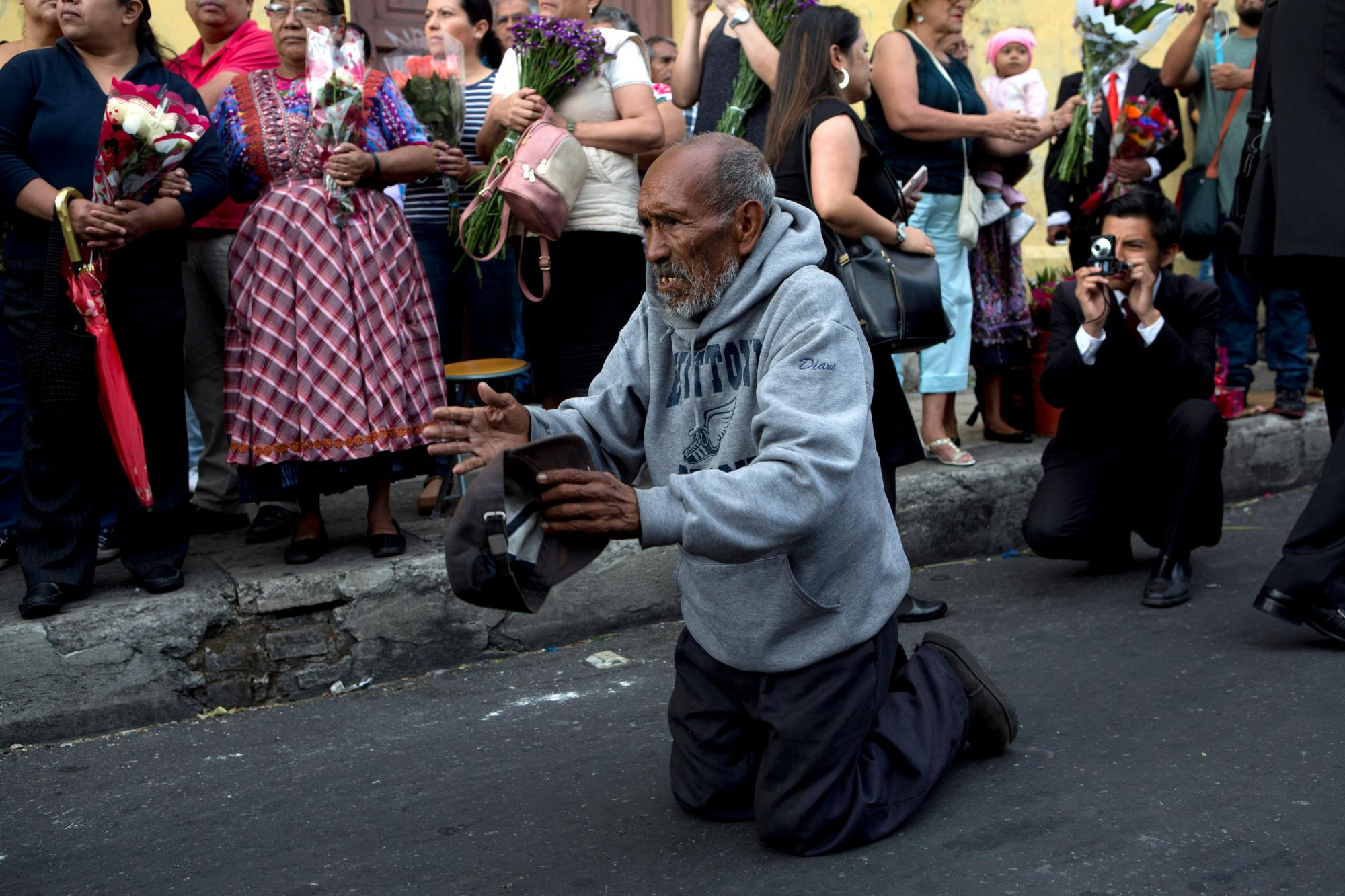 Un hombre reza en oración durante la procesión anual del Martes Santo, conocida como “La Reseña”, en el centro de la ciudad de Guatemala.