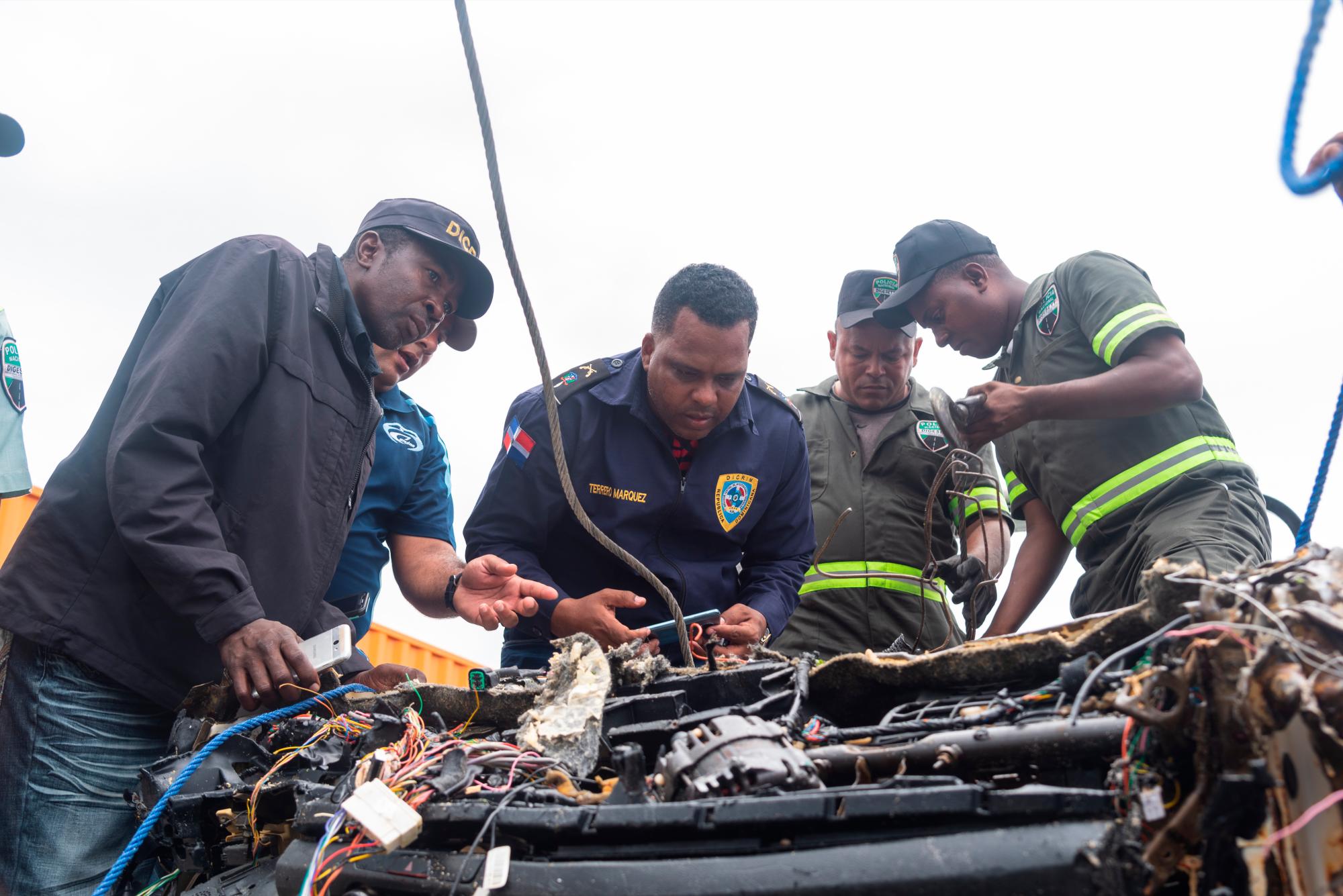Peritos del departamento DICRIM de la policía nacional inspeccionan el chasis del vehículo sacado de las aguas del mar Caribe y en el cual viajaba la pareja de turistas Portia Denises Revenelle y Orlando Moore en pasado 27 de marzo de 2019. Viernes 12 de abril de 2019.