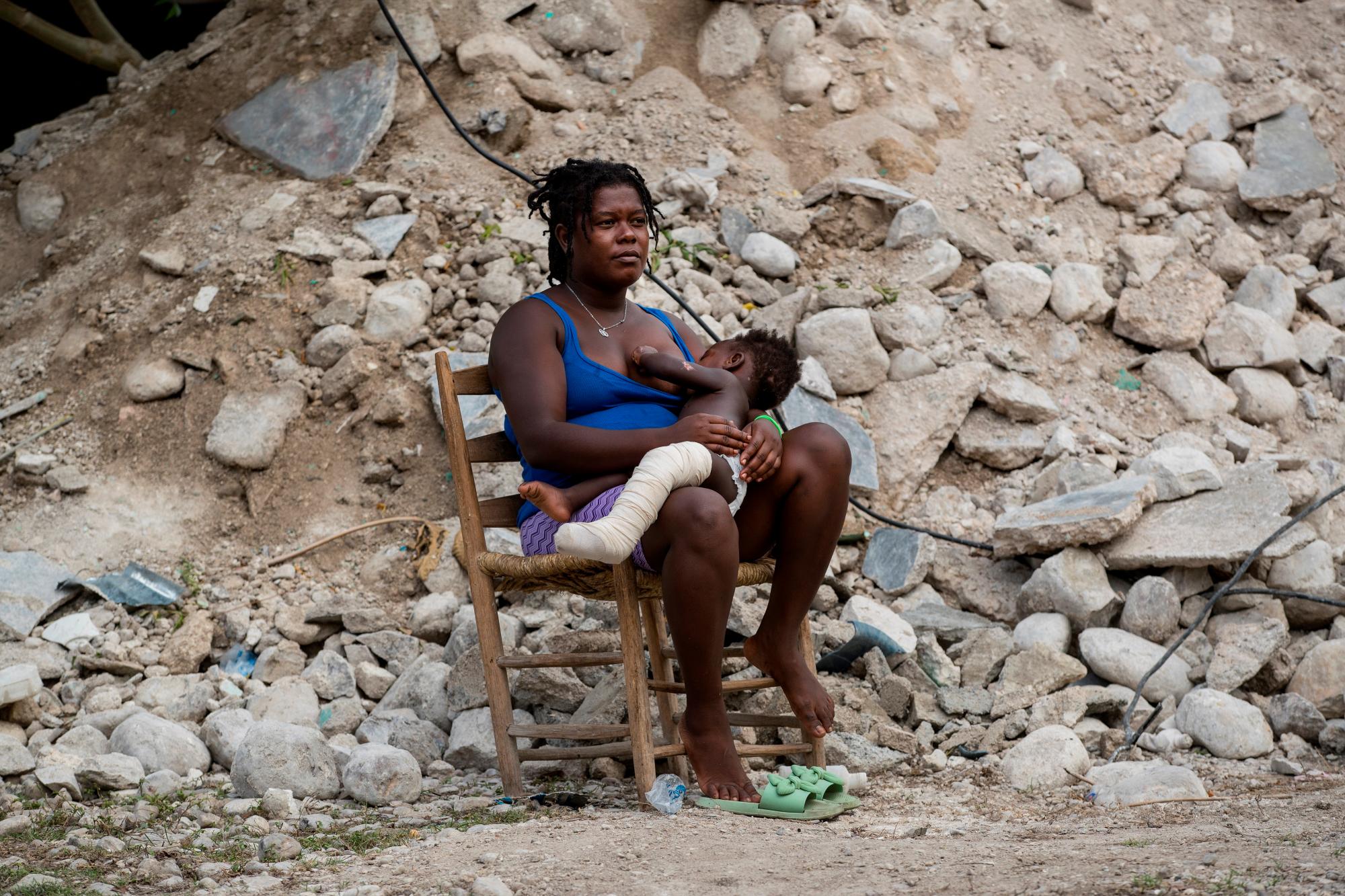 Altermard Roselina sostiene en brazos a su hijo Ándel Lovenia Lovensky junto a las ruinas de lo que fue su hogar y donde falleció su madre, este domingo en en Maniche (Haití). El movimiento telúrico de magnitud 7,2, registrado en el suroeste del país, ha destruido 52.923 viviendas y ha causado daños en otras 77.006 casas y ha dejado hasta el momento 2.207 personas fallecidas. EFE/ Orlando Barría