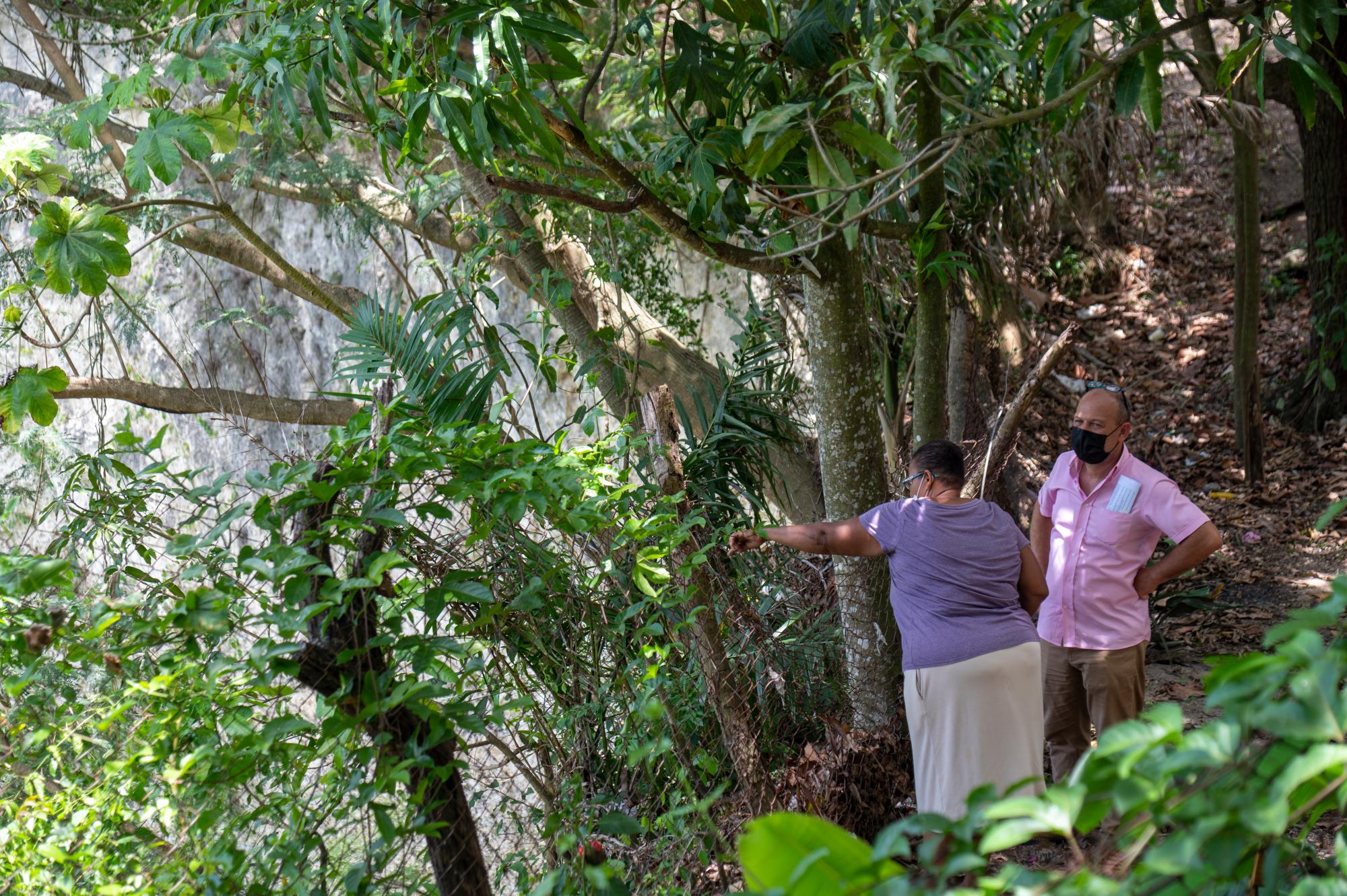Una señora muestra el precipicio dejado por la minería y que se divisa desde el patio de su casa en Cambelén, el 14 de junio de 2021.
