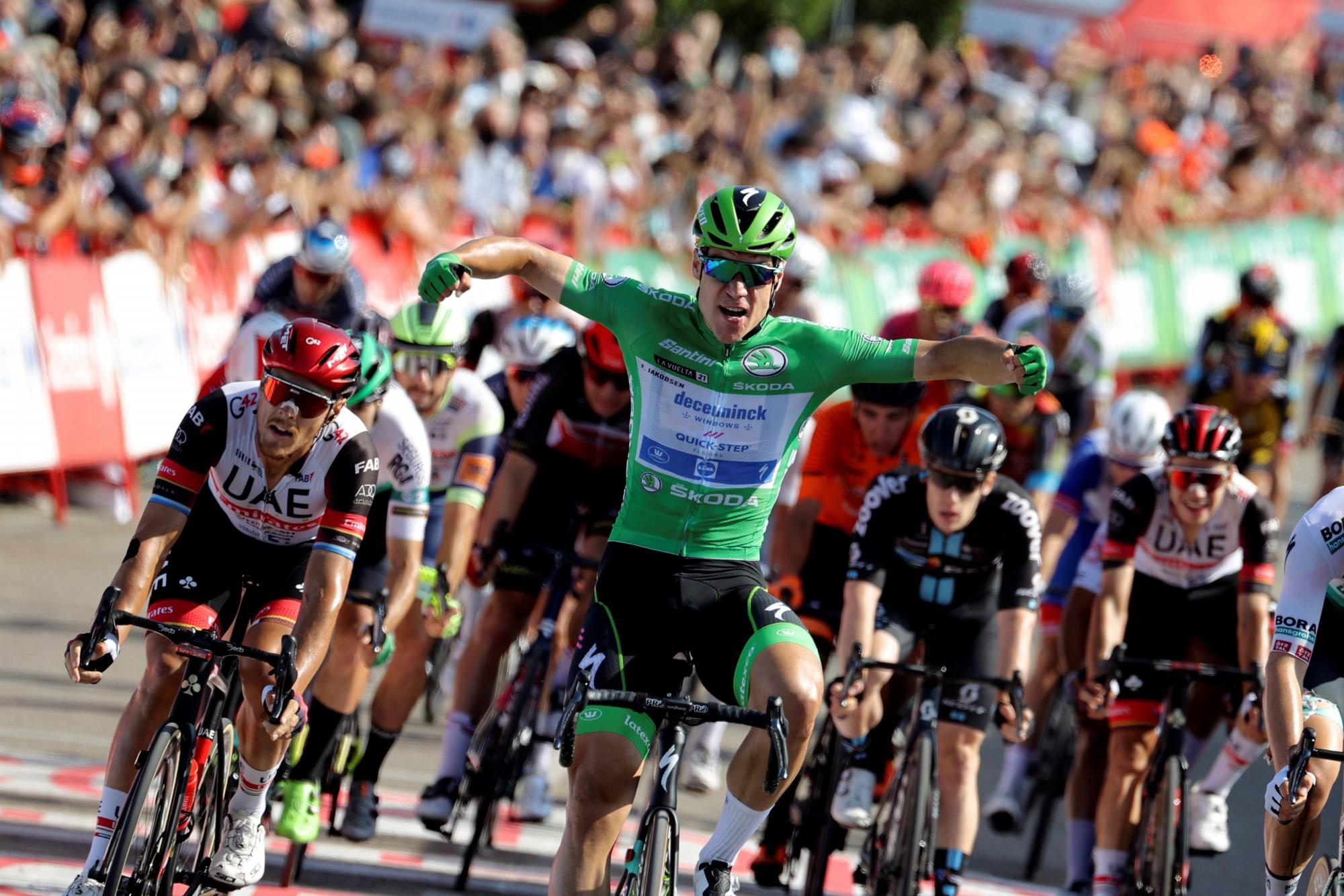 El neerlandés Fabio Jakobsen (c), del equipo Deceuninck Quick Step, celebra la victoria tras ganar al esprint la decimosexta etapa de la Vuelta, disputada este martes entre Laredo y Santa Cruz de Bezana, de 180 kilómetros, en la que mantuvo el maillot rojo de líder el noruego Odd Christian Eiking (EFE/Manu Bruque)