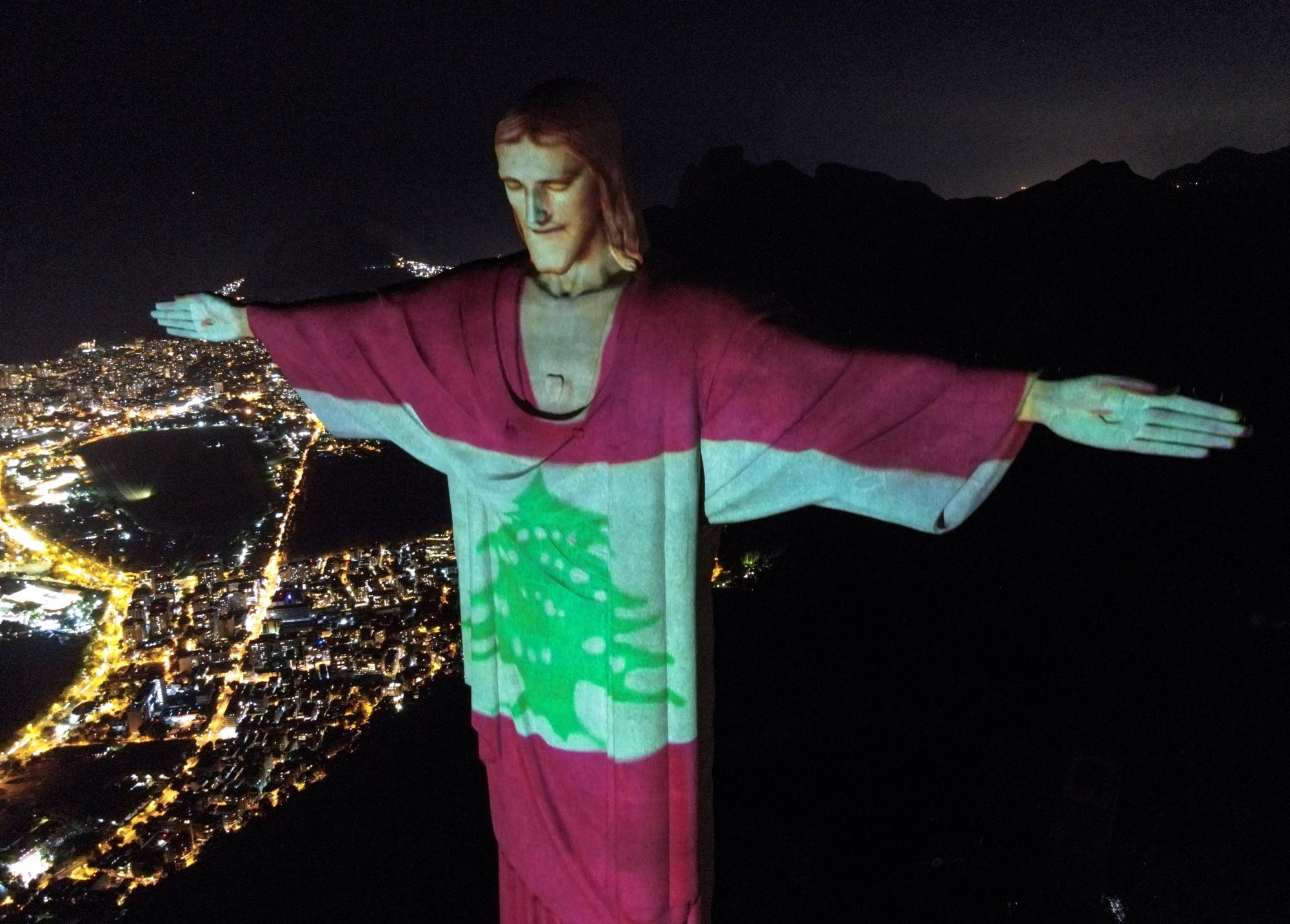 Fotografía tomada con un dron que muestra el monumento Cristo Redentor con la proyección de la bandera del Líbano en honor a las víctimas de la explosión que dejo más de 100 muertos y miles de heridos en Beirut, hoy en Río de Janeiro (Brasil). EFE/Antonio Lacerda