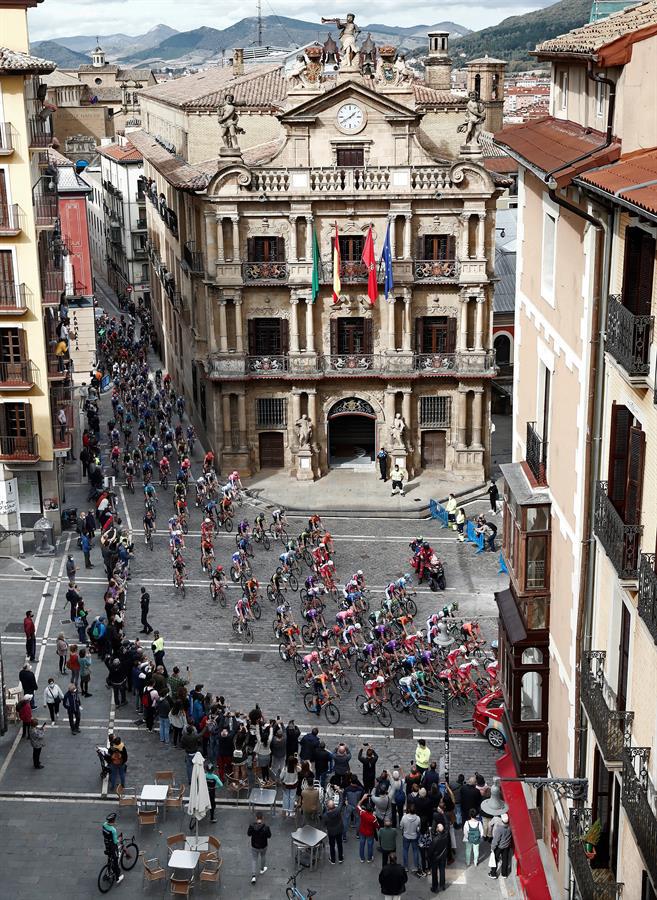  El pelotón a su paso por el Ayuntamiento de Pamplona durante la segunda etapa de la Vuelta Ciclista a España con salida en Pamplona y llegada a Lekunberri, de 151,6km de recorrido. (EFE/Jesús Diges)