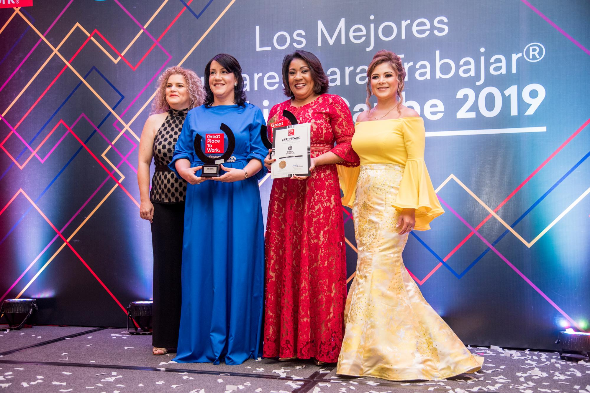 Al centro, Ivelisse Pérez y Florangel Suero de Grupo Universal reciben el galardón de Patricia Muñoz y Leslie Davidovich, gerente general regional de Great Place to Work.