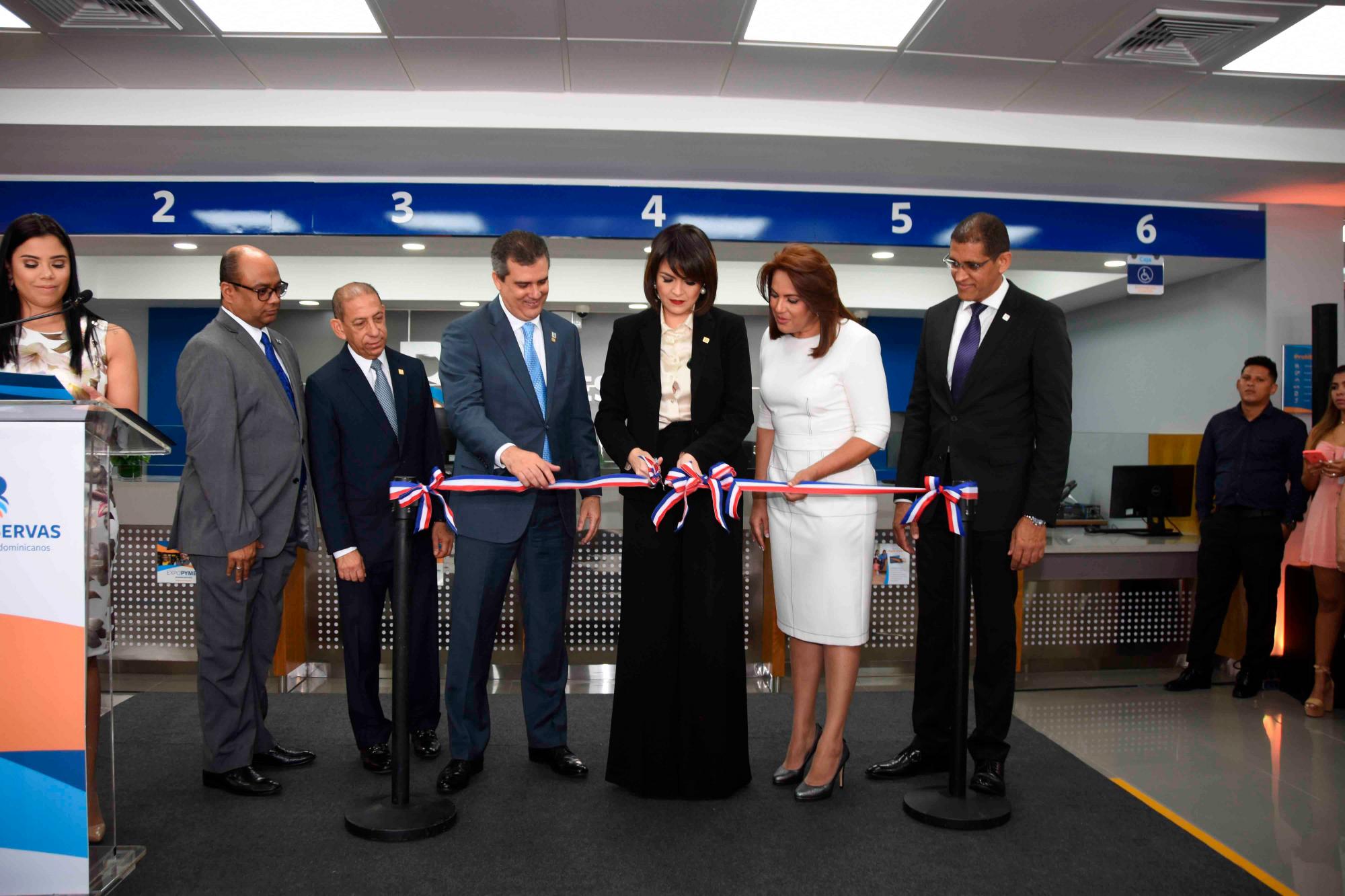 En el corte de cinta la acompañan, desde la izquierda, los ejecutivos de la entidad bancaria Bertilio Fernández De la Cruz, Julio Páez, Carlos Cabral, Carmen Pujols, gerente de la nueva oficina; y Pablo de la Rosa.   