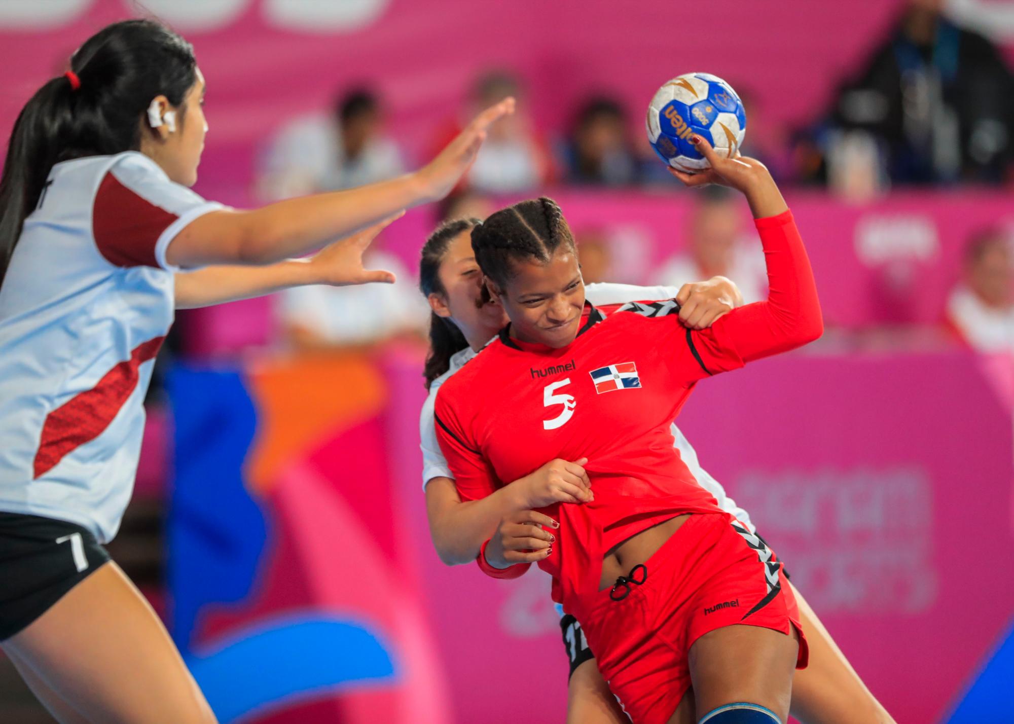 Danilza Liranzo del equipo de balonmano de República Dominicana, derecha, y Kelly Servat durante la competencia en Villa Deportiva Nacional-Videna en los Juegos Panamericanos de Lima 2019.