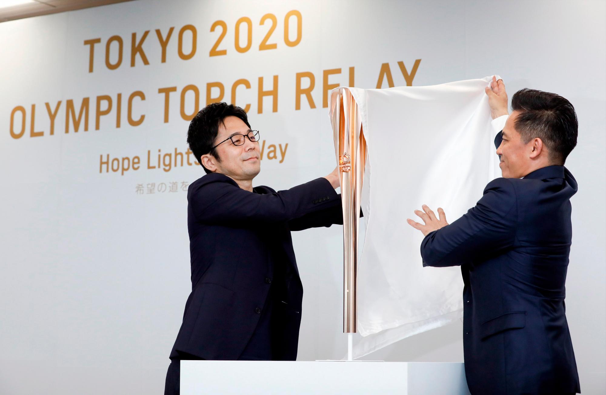 Tokujin Yaoshioka (izq), diseñador jefe de la antorcha olímpica de los Juegos de Tokio 2020, y Tadahiro Nomura (dcha), tricampeón olímpico de judo, posan durante la ceremonia de presentación de la antorcha este miércoles en Tokio (Japón), un año antes de la llegada de la llama olímpica al país.