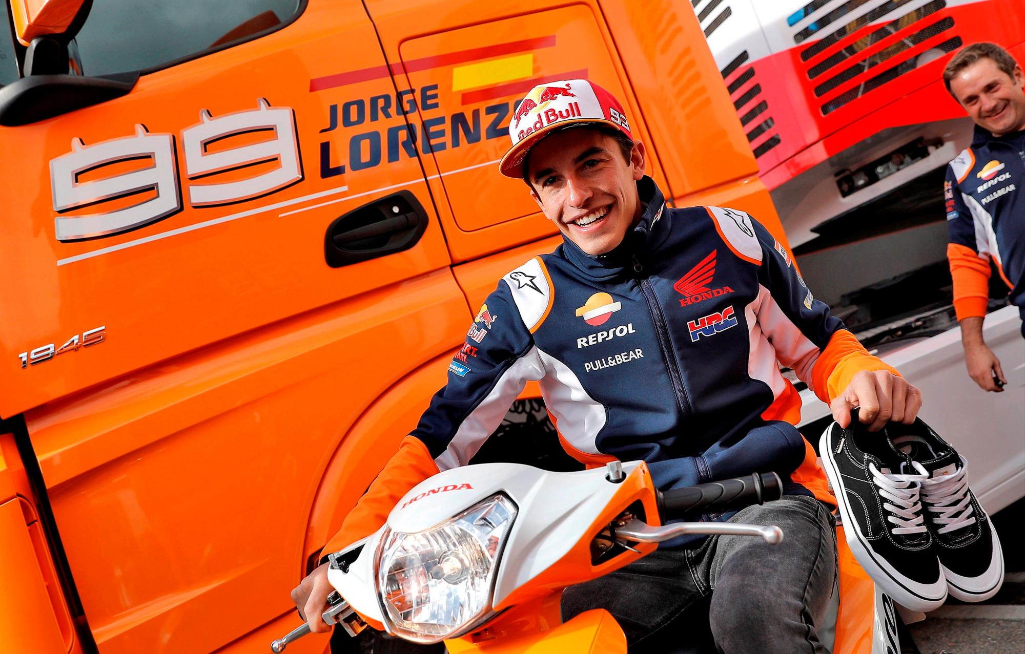 El piloto de motociclismo y campeón del mundo de Moto GP, Marc Márquez, pasa con su Honda por delante del camión de Jorge Lorenzo este jueves en Cheste (Valencia) donde comienzan los preparativos para la celebración del Gran Premio Motul Comunitat Valenciana.
