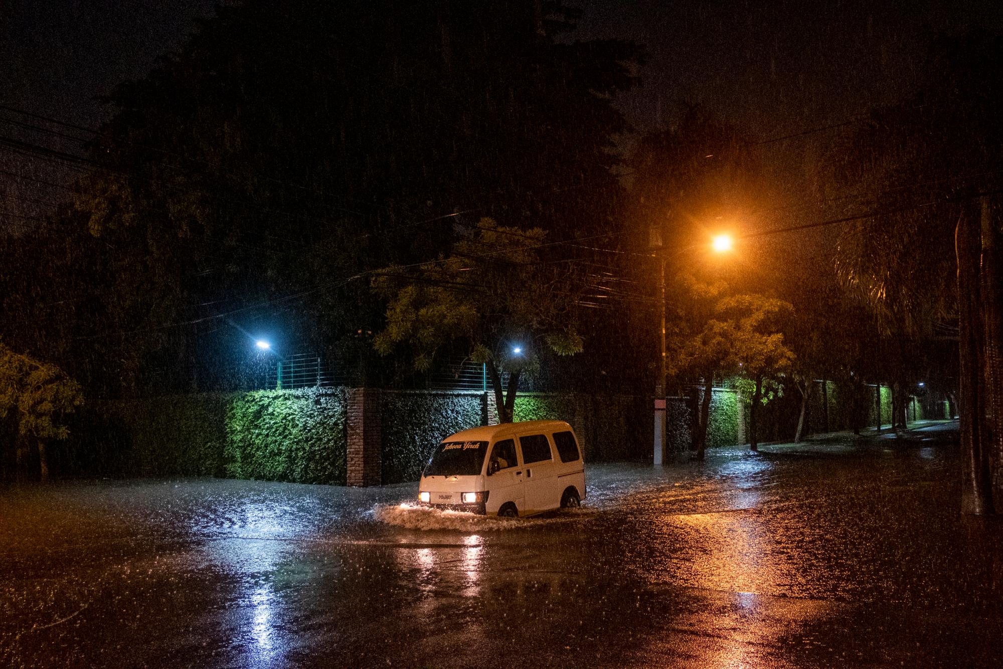 Santo Domingo, RD: un minibus cruza un charco de agua a riesgo de inundarse en la calle Andrés Julio Aybar esquina Federico Geraldino del ensanche Piantini.