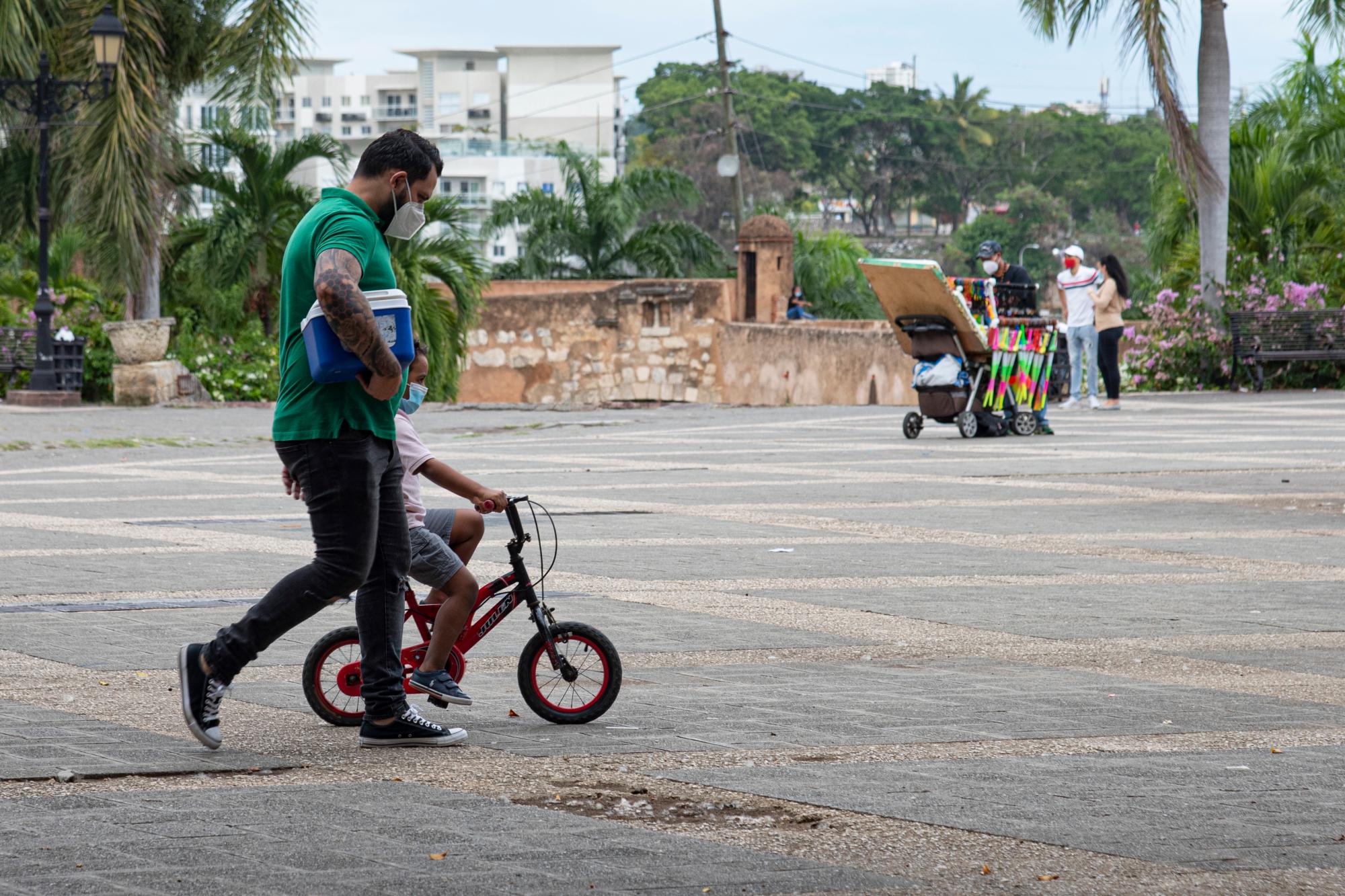 Padre acompaña a su hijo en su bicicleta en el Alcázar de Colón.