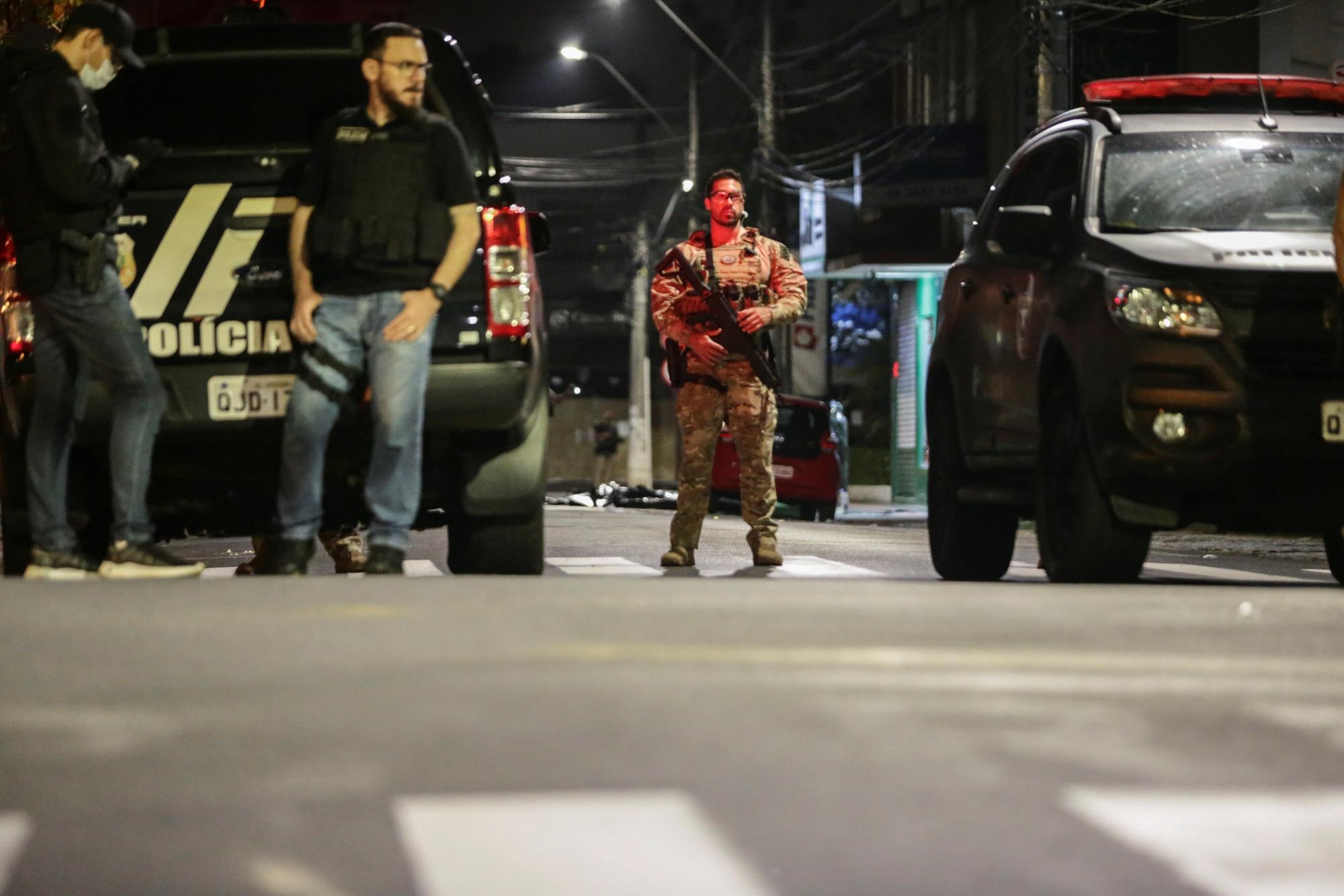 Miembros de la Policía vigilan el local en donde los bandidos dejaron explosivos escondidos, durante el robo de un banco en la madrugada de este martes, en Criciuma. (EFE/ Guilherme Hahn)