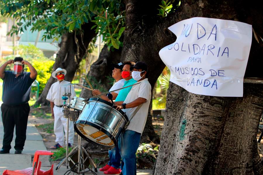 Una banda musical actúa en una calle a cambio de una ayuda para una olla común, el miércoles 20 de mayo de 2020, en Santa Cruz (Bolivia). Trompetas, tambores y platillos animan a los transeúntes a cambio de una ayuda para comer, en estos tiempos en los que hasta la música se queda sin clientes en Bolivia. 