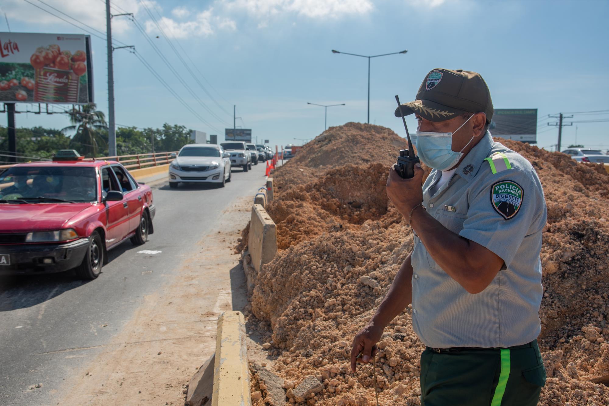 Un agente de la DIGESETT dirige el flujo vehicular que se limita a un carril sobre el elevado del kilómetro 12 de la autopista Duarte. (Foto: Eddy Vittini)