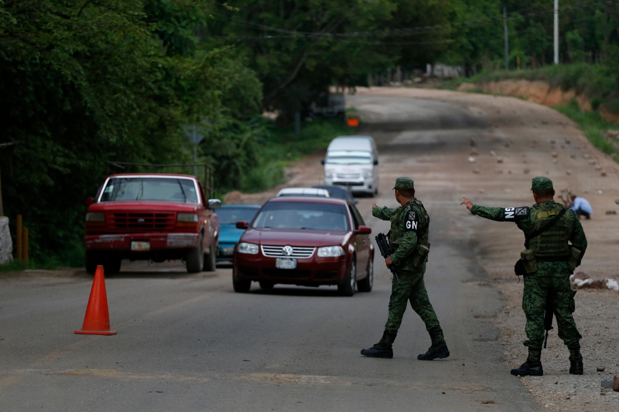 Soldados que llevan brazaletes de la Guardia Nacional de México mandan a detener automóviles en un puesto de control temporal en busca de migrantes ilegales en furgonetas y camiones que viajan al norte de Ciudad Cuauhtemoc, Estado de Chiapas, México.