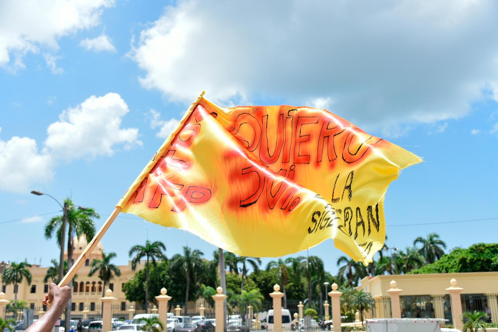 Bandera en protesta del 30% del AFP y de fondo el Palacio Presidencial de la República.