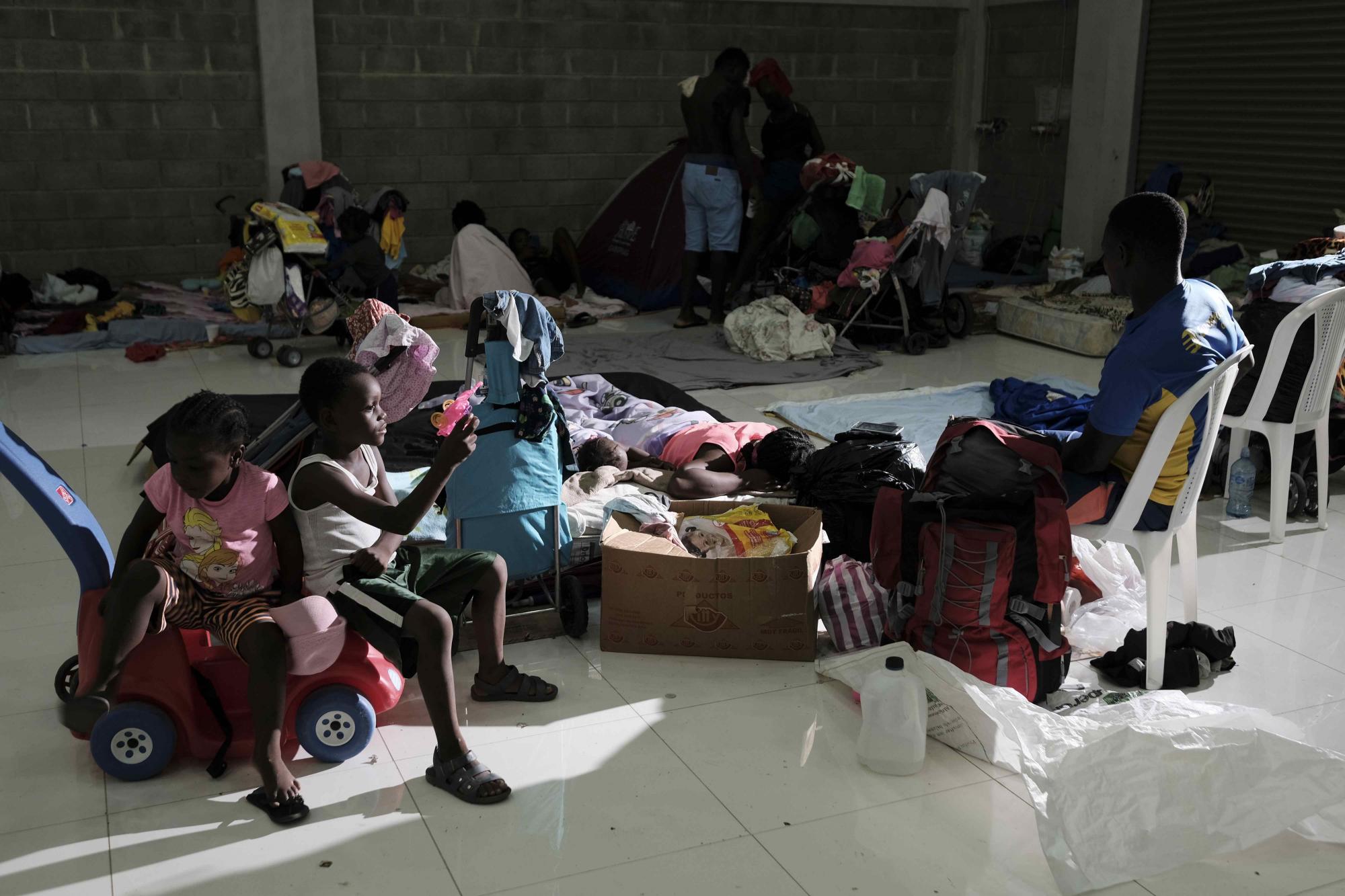 Familias haitianas pasan el día hoy, en un centro comunal en la zona de Palmar Norte, a 259 kilómetros de San José (Costa Rica).  (EFE/ Jeffrey Arguedas)