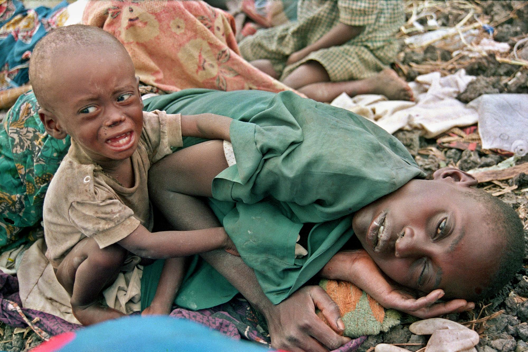 En esta foto del 27 de julio de 1994, un niño refugiado ruandés hutu intenta desesperadamente despertar a su madre en el campamento Munigi en Zaire, ahora conocido como Congo. La magnitud de los asesinatos en 1994 era inimaginable, pero los informes y las fotografías tomadas en ese momento ayudaron a informar al mundo de los horrores del genocidio. 