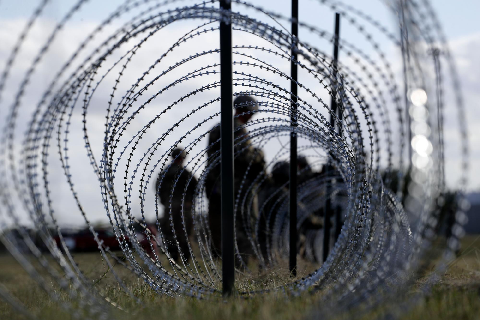Miembros del Ejército de los EEUU construyen una cerca de alambre alrededor del área para tiendas de campaña cerca del Puente Internacional de EEUU y México, en Donna, Texas.