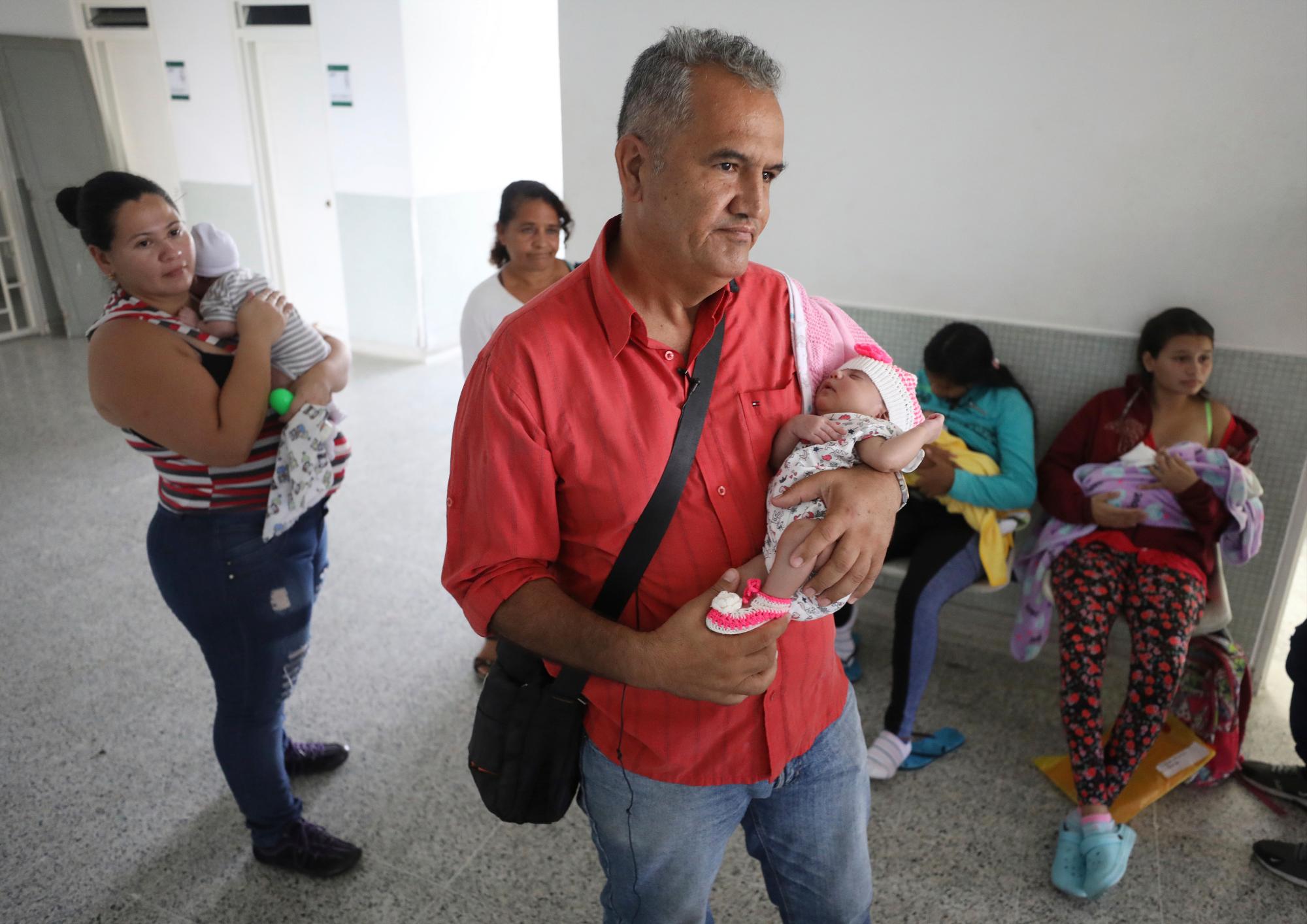 El expolicía venezolano Eduardo Bravo acuna a su hija Aranza Gabriela Bravo mientras espera en el hospital Erazmo Meoz a recibir su certificado de nacimiento, en Cúcuta, Colombia, el jueves 2 de mayo de 2019.