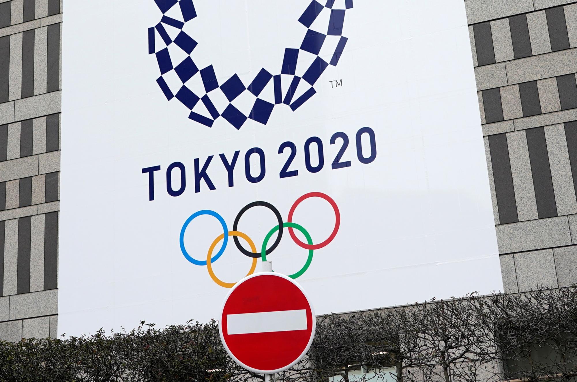 Una señal de prohibido el paso se sitúa frente a un cartel anunciador de los Juegos Olímpicos de Tokio 2020 en un edificio oficial en Tokio, Japón, este miércoles. (EFE/ Franck Robichon)