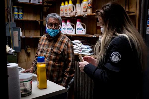 Ismael Taveras (i) mientras atiende a una clienta en el ‘Graham Laundromat’, el negocio familiar en el que trabaja en Brooklyn, Nueva York (EE.UU.).