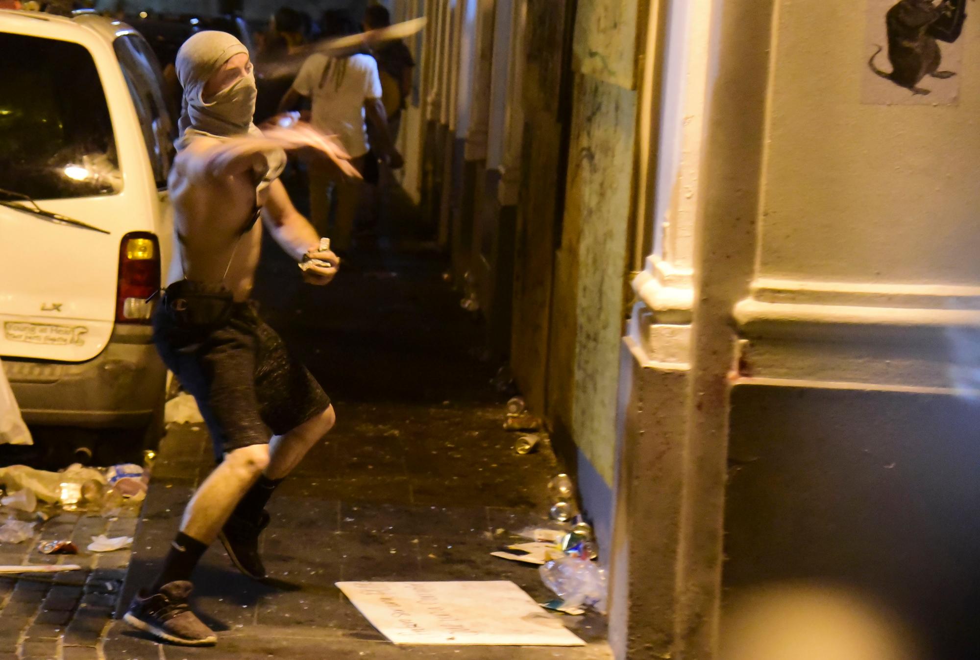 Un manifestante arroja piedras a la policía durante los enfrentamientos en San Juan, Puerto Rico, el miércoles 17 de julio de 2019.