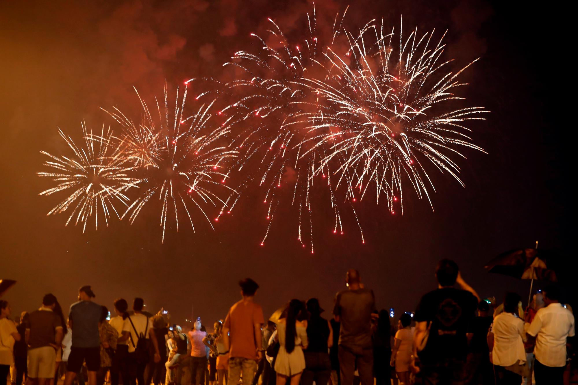Varias personas observan este sábado el lanzamiento de los fuegos artificiales con motivo de la celebración de los 500 años de la fundación de La Habana.